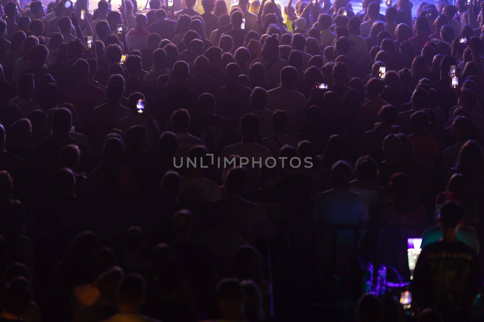 An attentive audience in a dimly lit venue, focused on the live performance.
