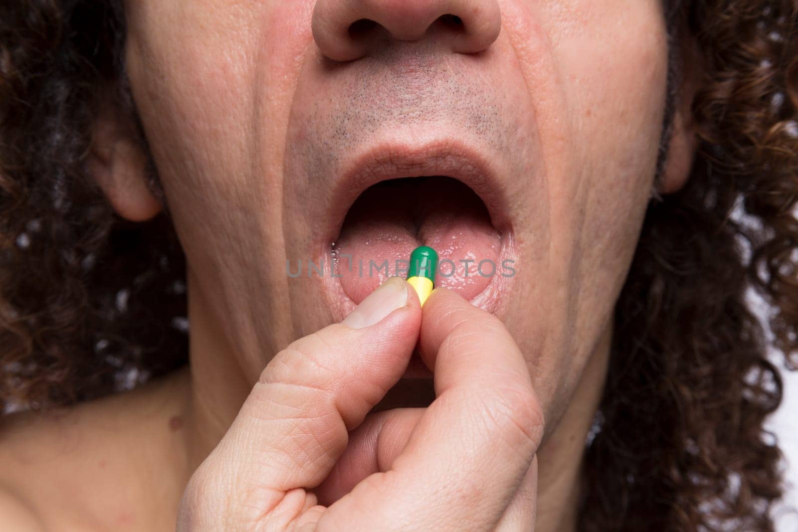 Cropped portrait of mediterranean looking man taking medicine pill