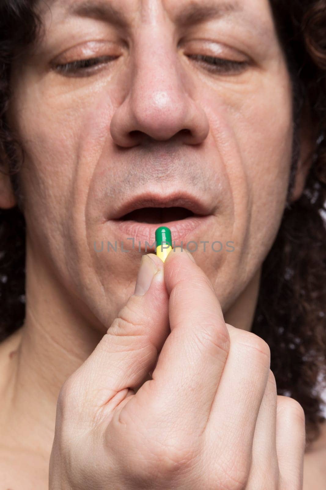 Cropped portrait of mediterranean looking man taking medicine pill