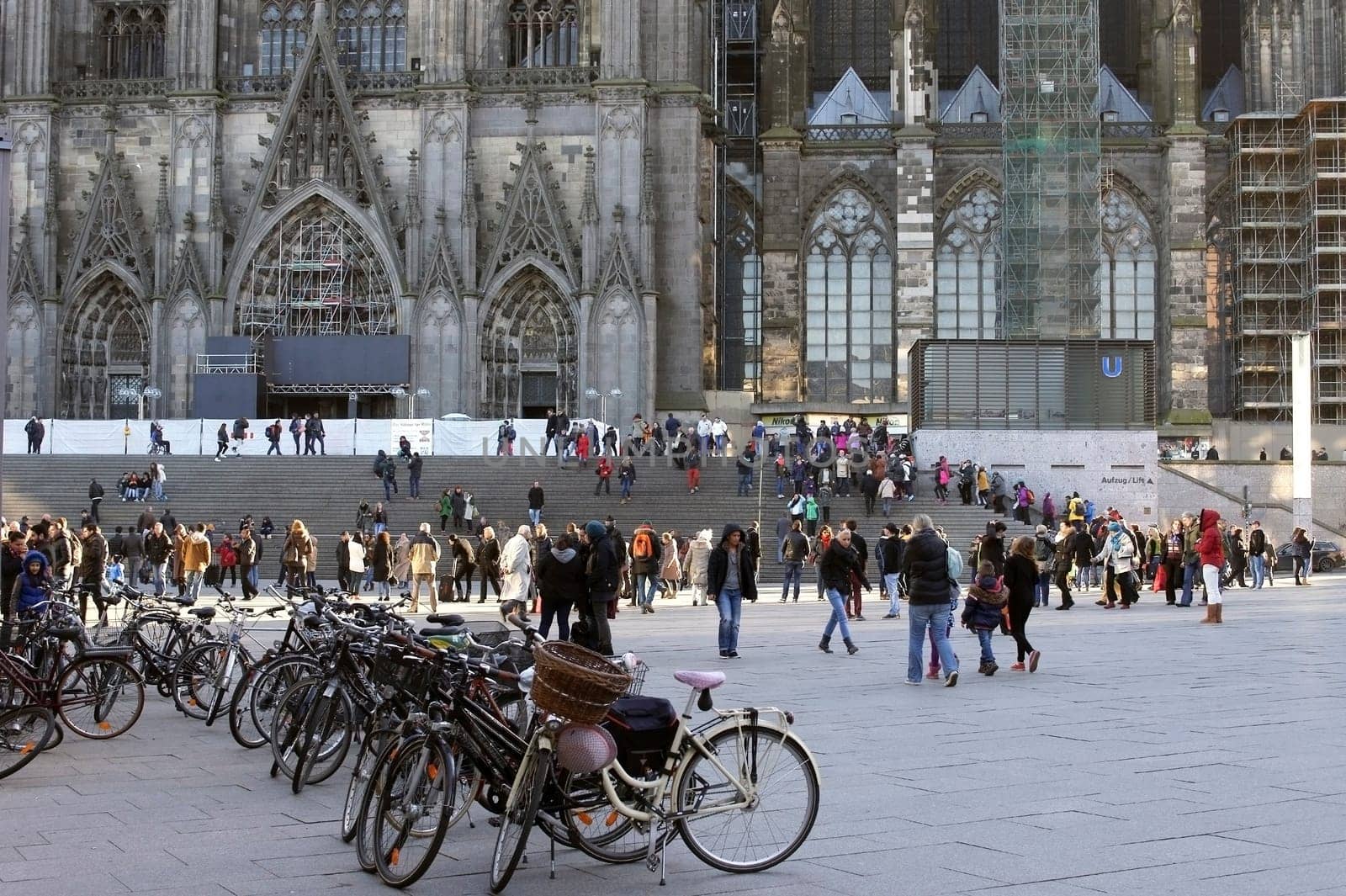Cologne,Germany – February 02,2014: Tourists and travellers on the station forecourt walk up the stairs to Cologne Cathedral on February 2,2014 in Cologne.