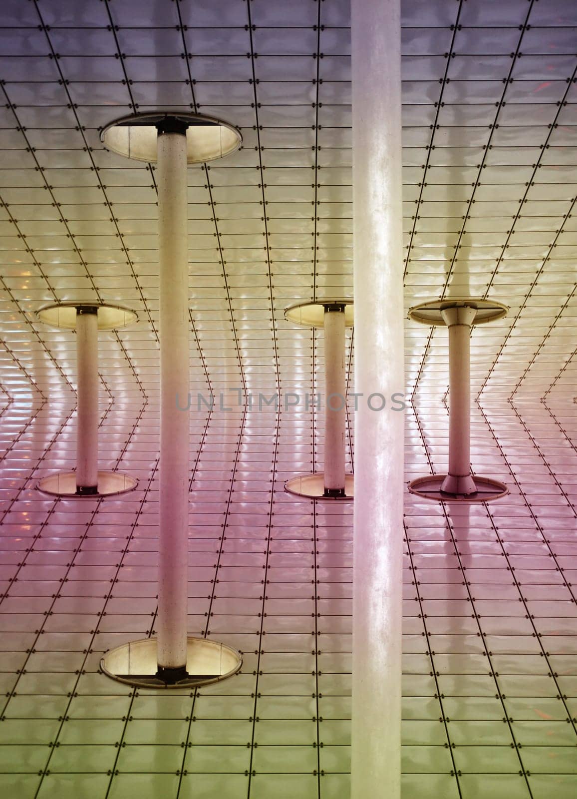 The abstract photograph of the underside of a mirrored canopy with a striking cladding and supports.