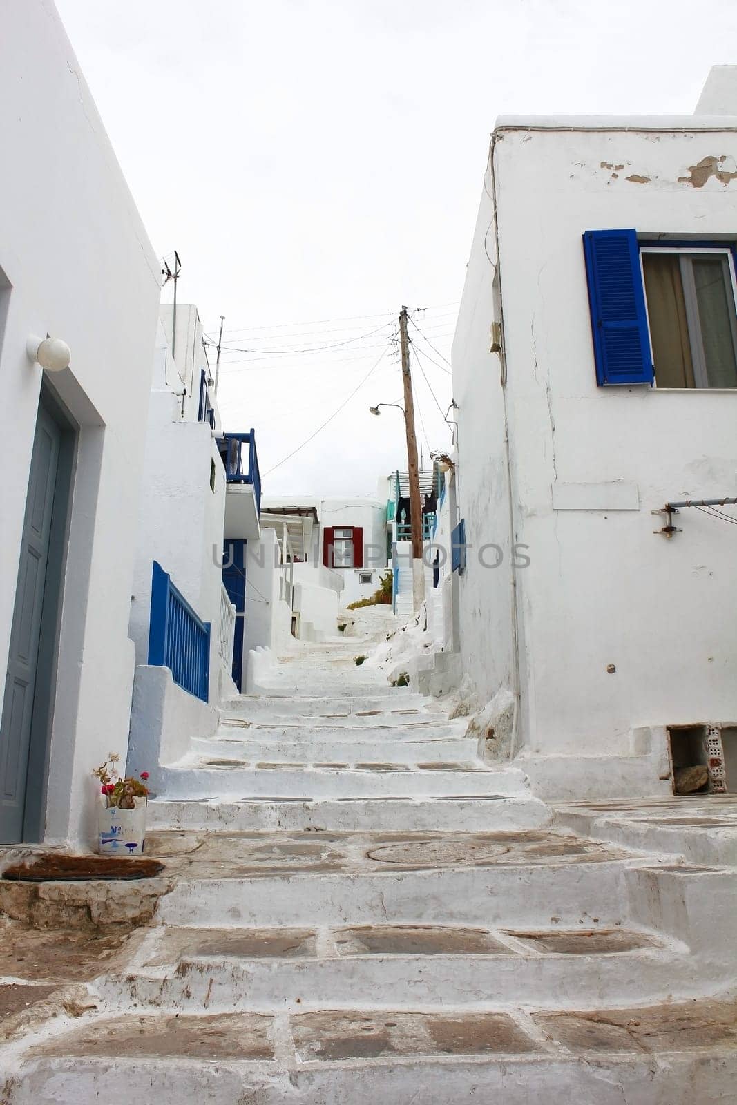 A small alley in the town of Fira on the island of Mykonos Greek with the.copestone street and the white houses..
