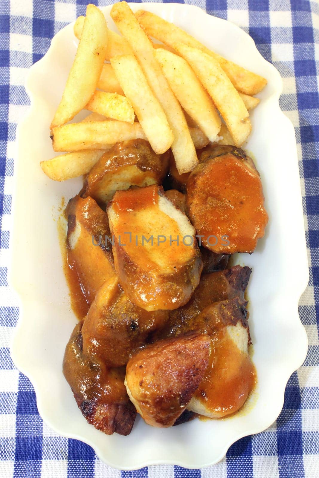 a currywurst with fries and salad