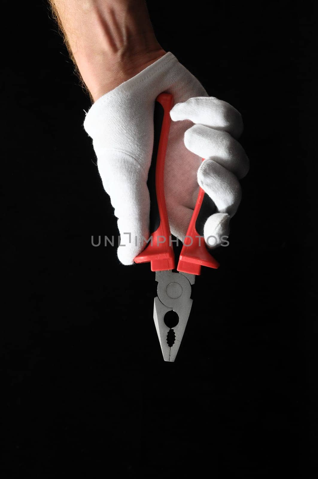 Pliers and Hand on a Black Background