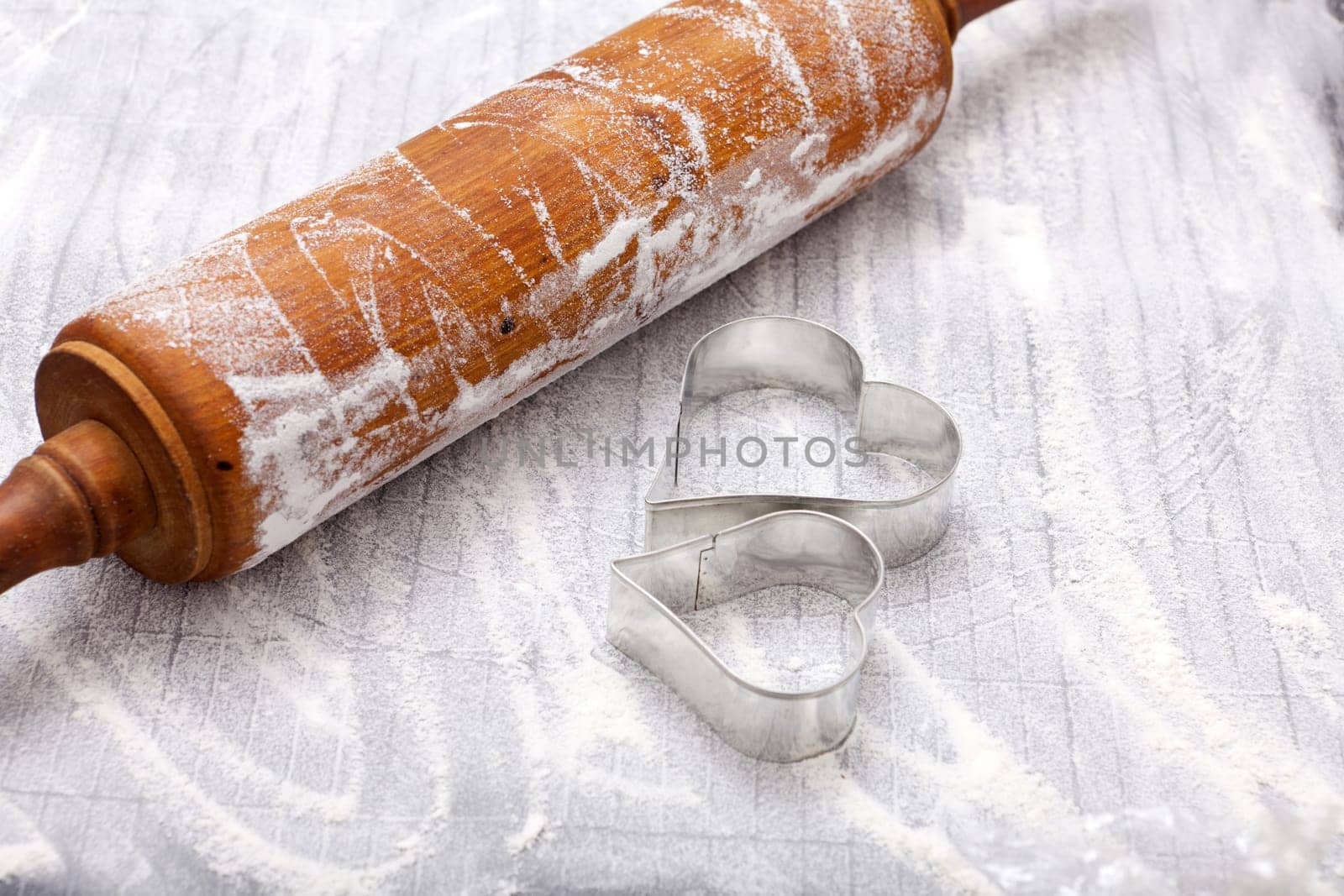 Dough roll and cookie cutter on baking mat
