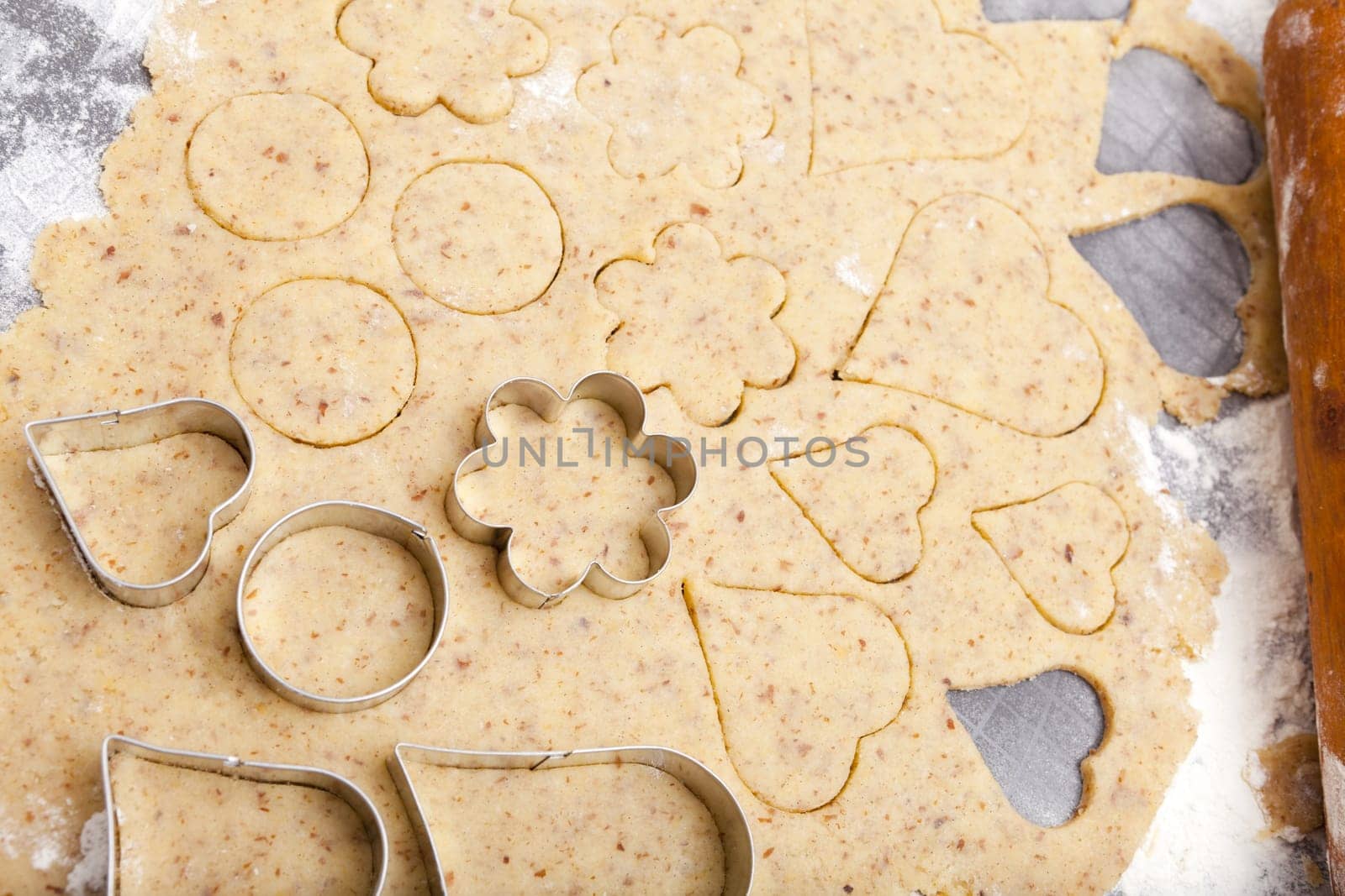 Many different cookie shapes on dough