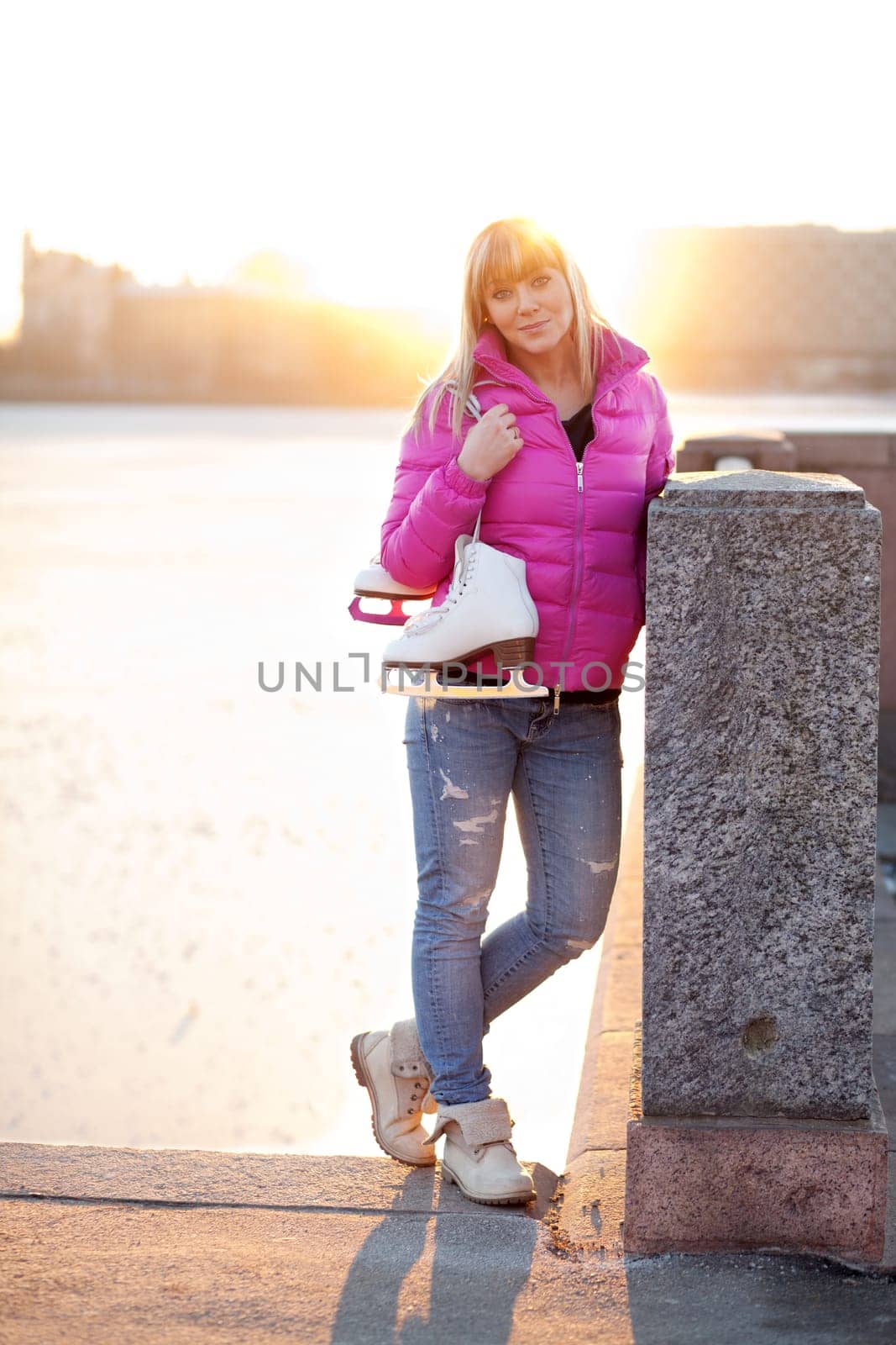 Beautiful young blond woman standing with her ice skates