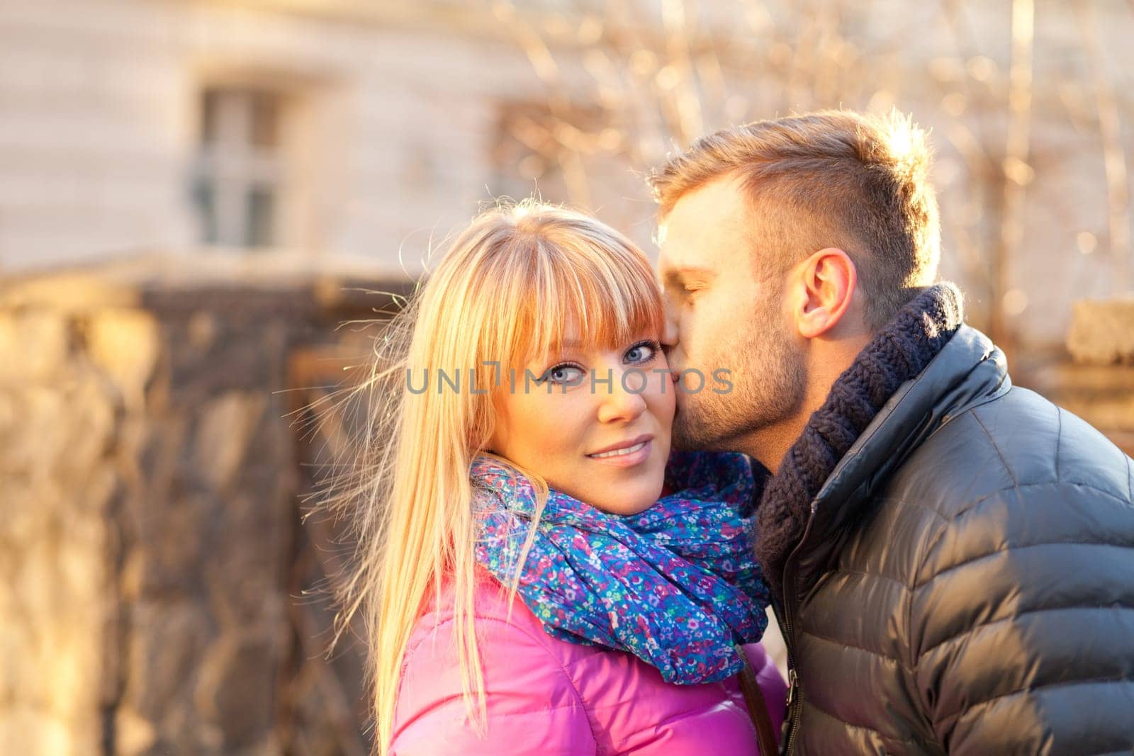 Young man kissing his girlfriend on the cheek