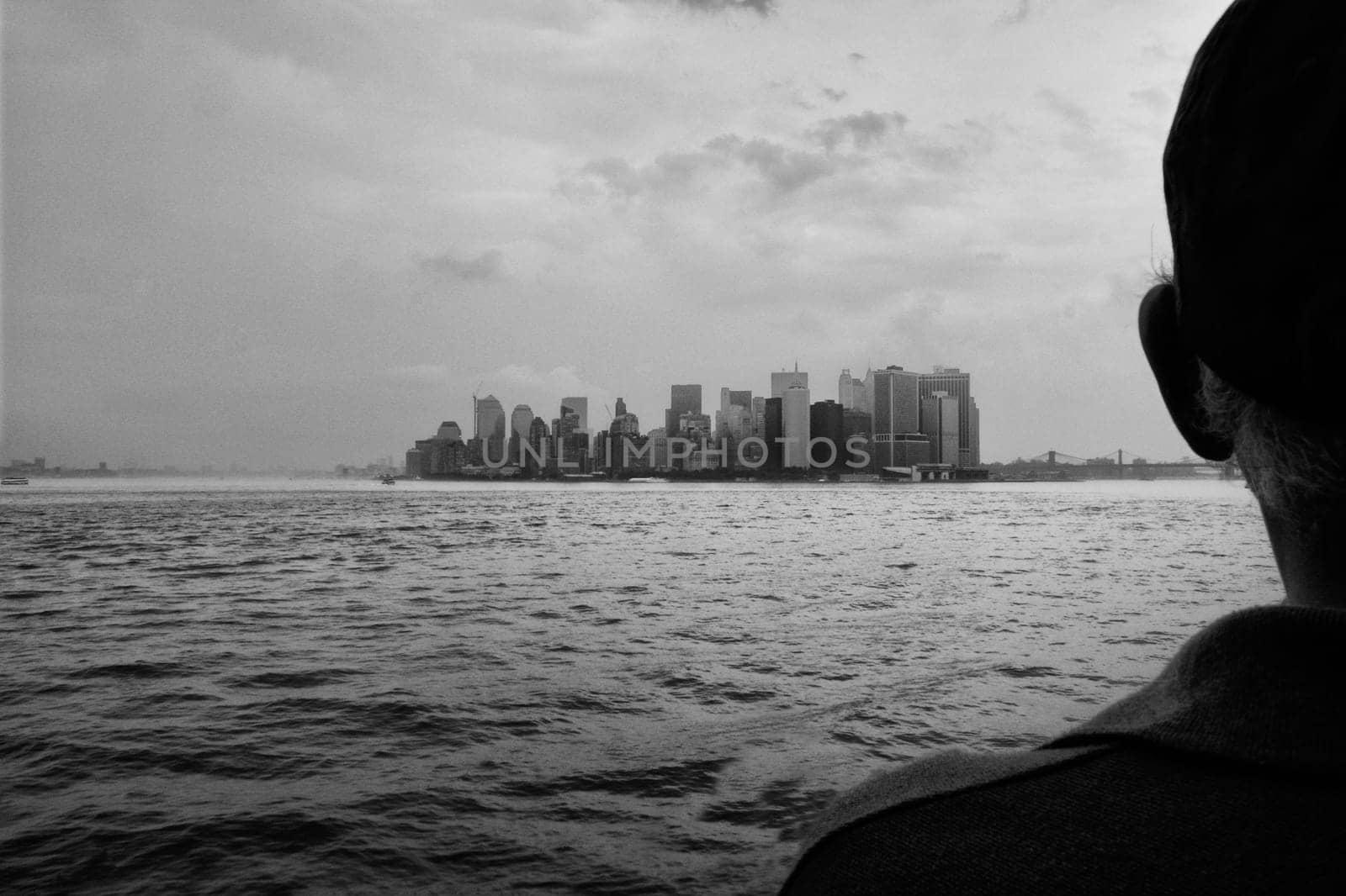 Elder man observes the Manhattan Slyline on board of Staten Island Ferry