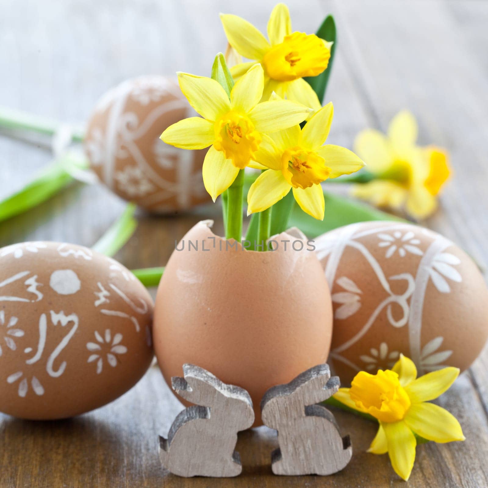 Fresh daffodils in eggshell and painted Easter eggs