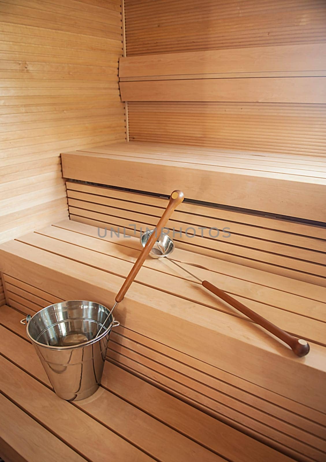 Bucket and scoop in wooden finnish sauna background.