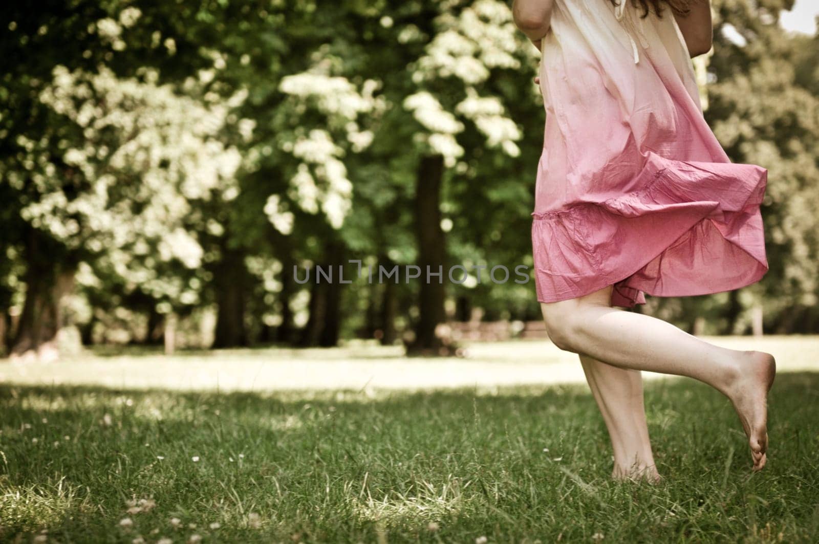 Running barefoot in grass - detail of woman's feet