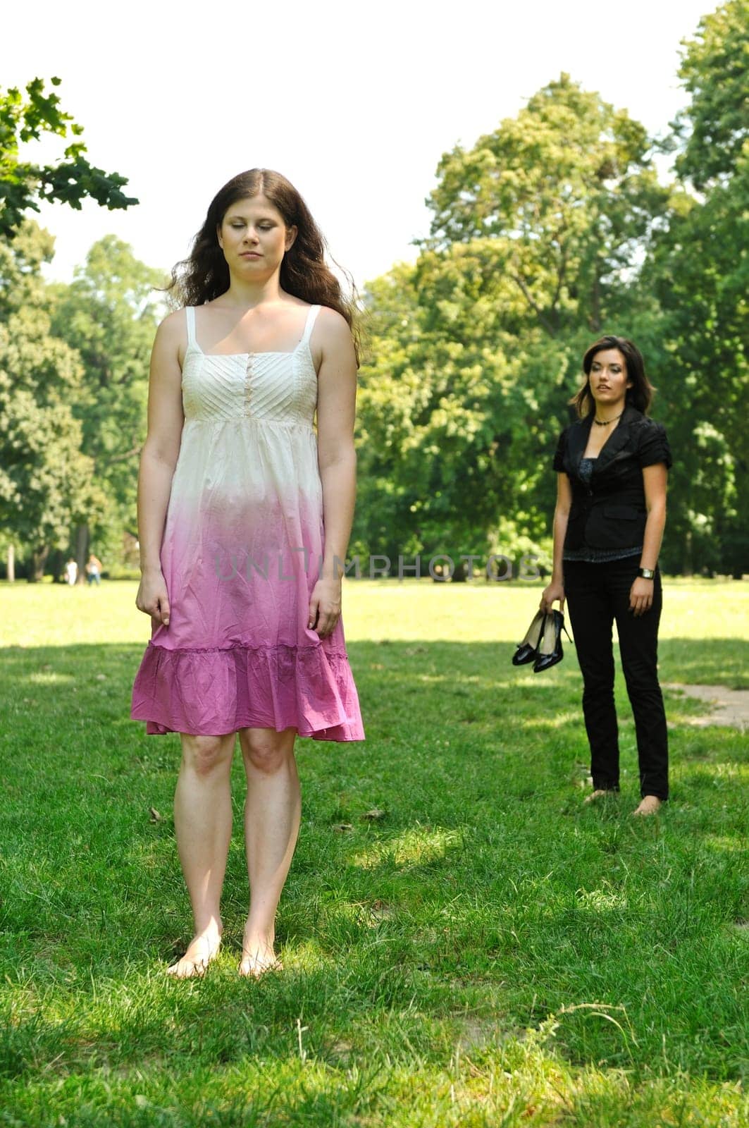 One girl is offended and her friend is calling for her - outdoors in park