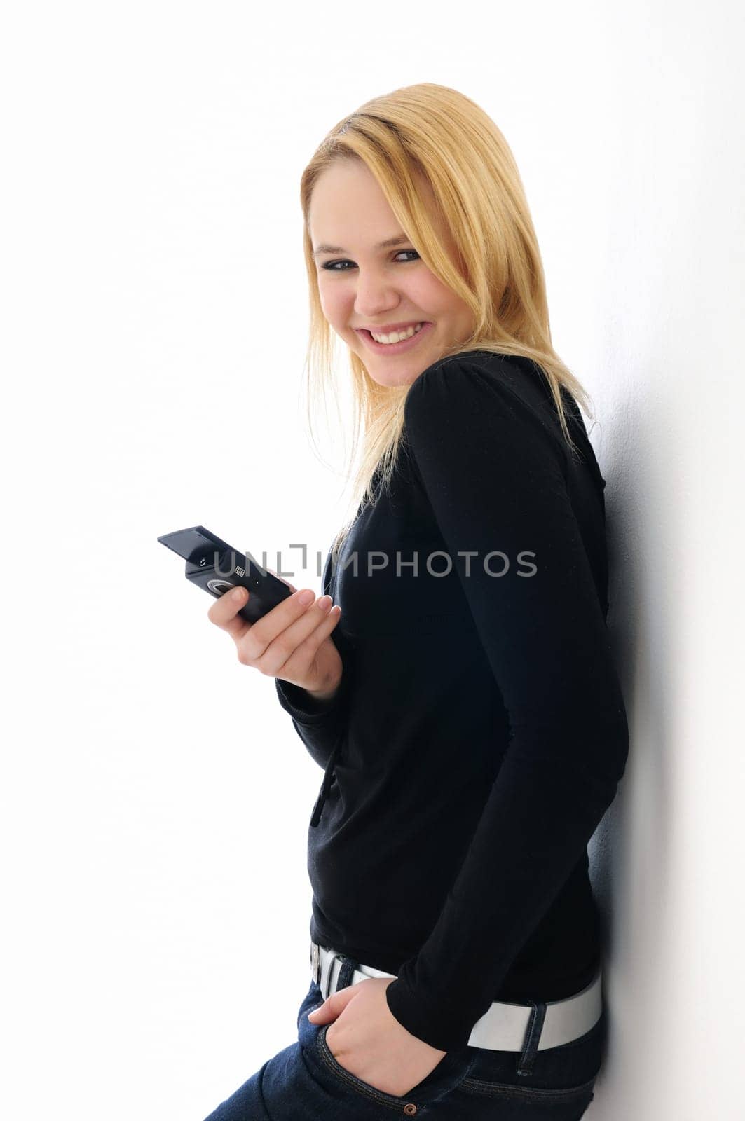 Blond smiling teenage girl holding mobile phone on white background