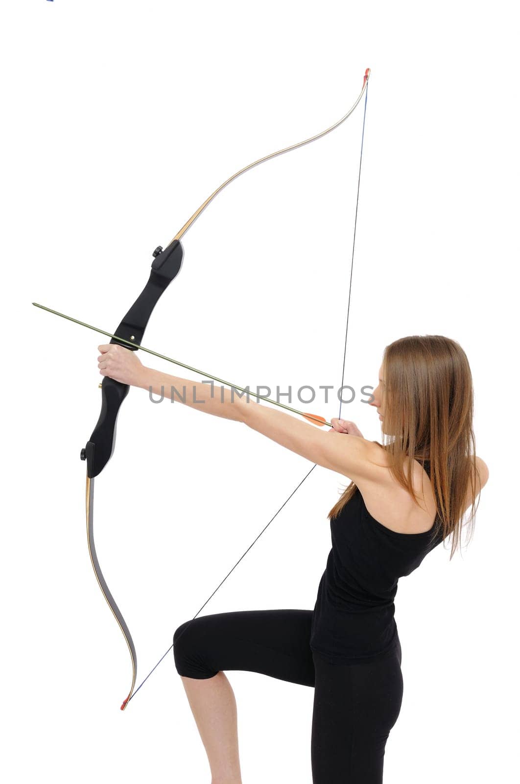Woman on knee aiming with bow - studio shot