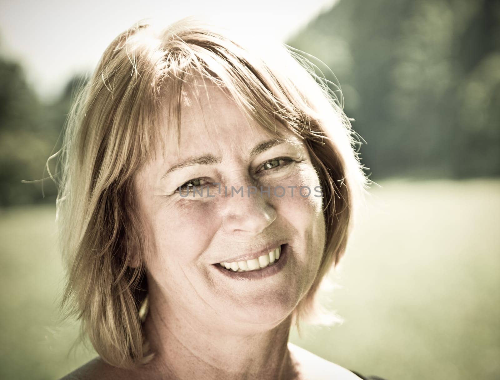 Portrait of happy smiling senior woman - outside on sunny day