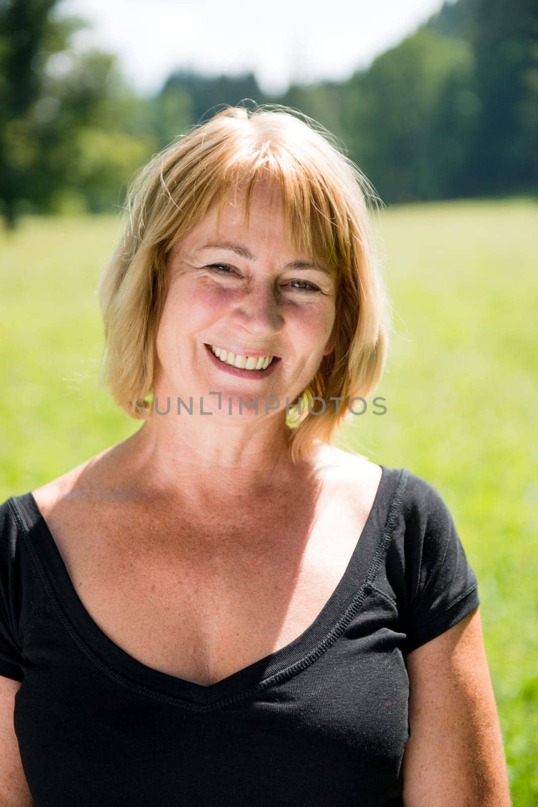 Portrait of happy smiling senior woman - outside on sunny day