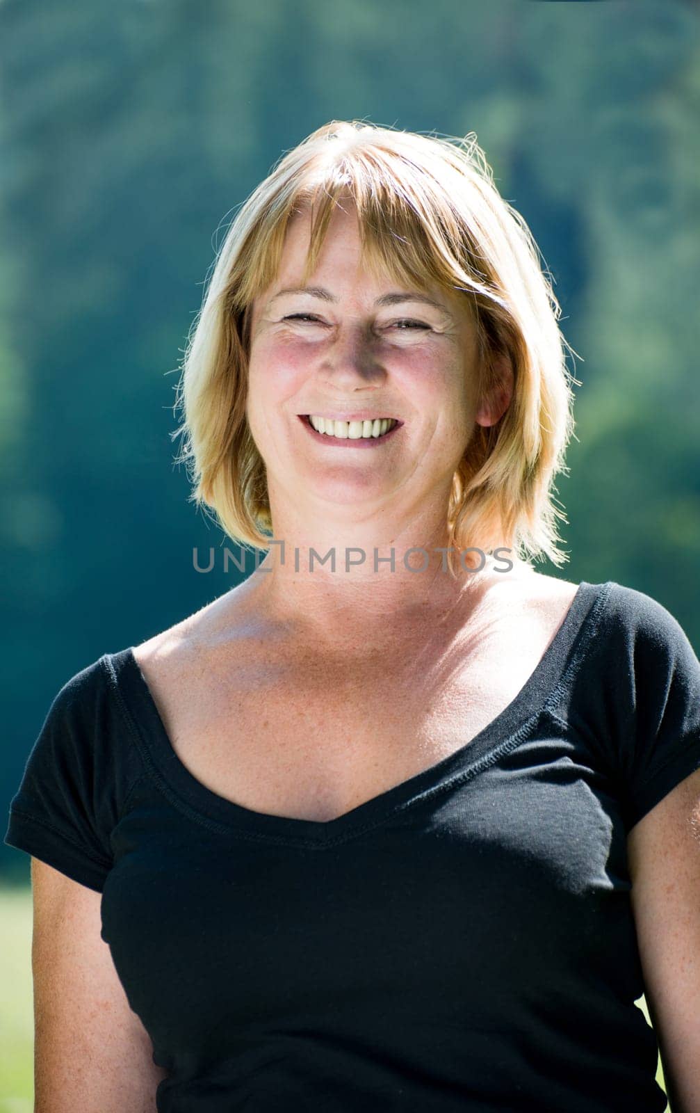 Portrait of happy smiling senior woman - outside on sunny day