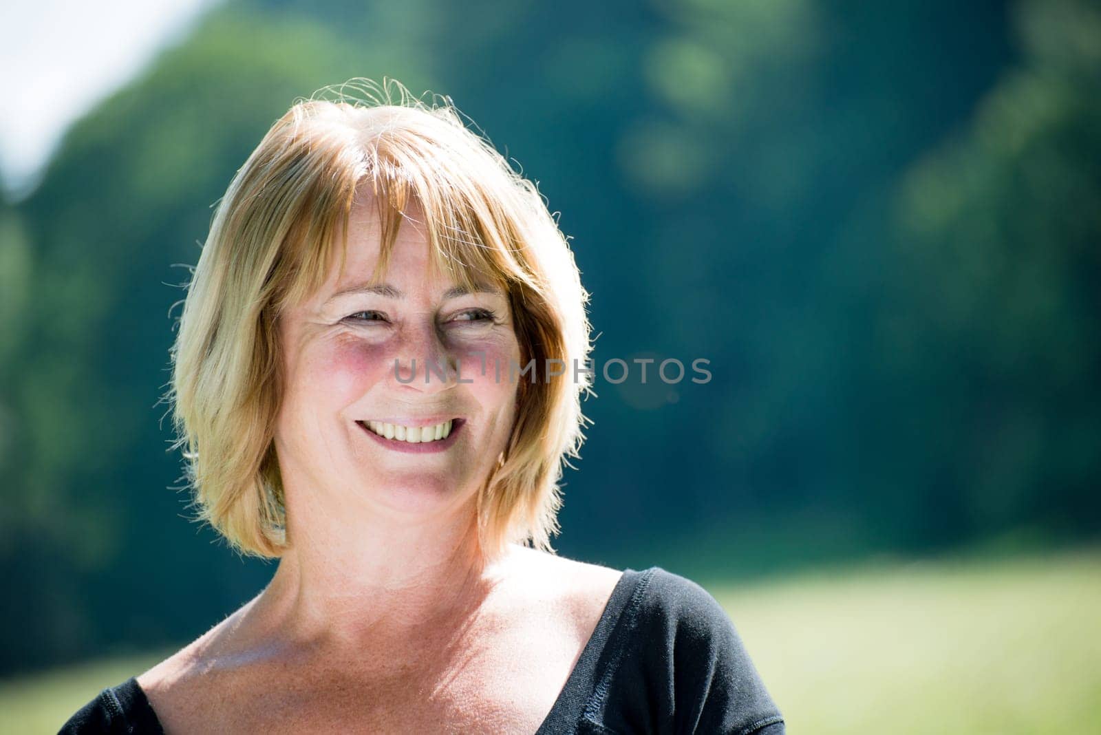 Portrait of happy smiling mature woman - outdoor in nature