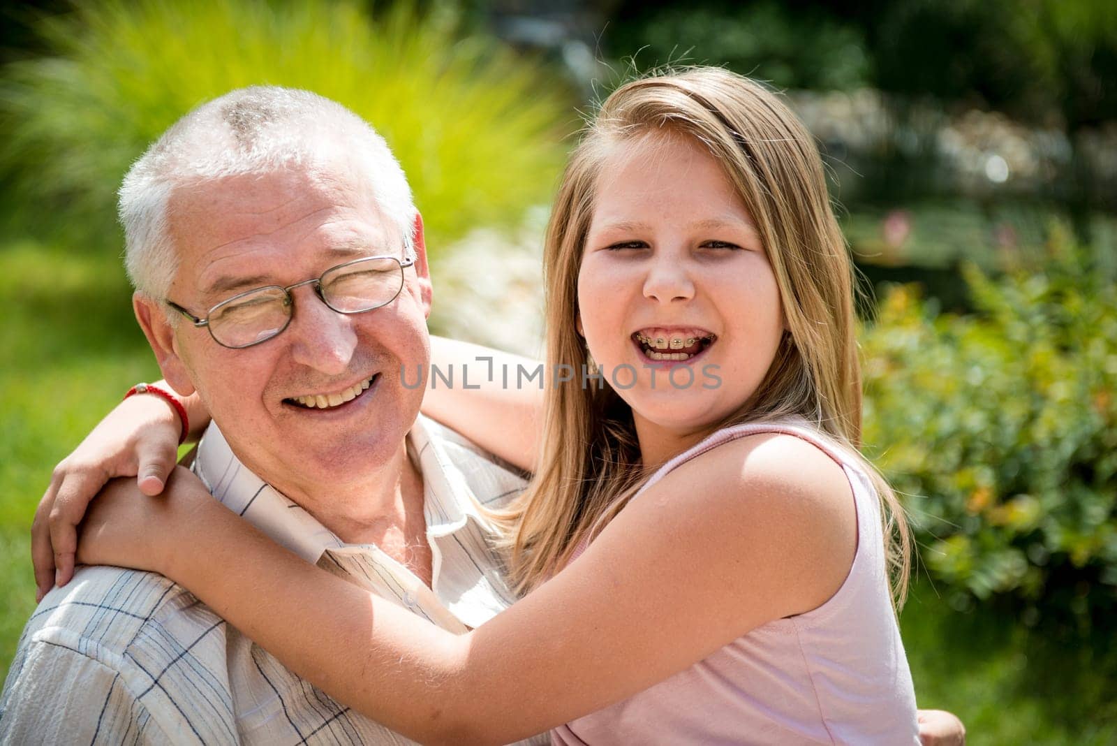 Portrait of grandchild with grandfather - outdoor in backyard