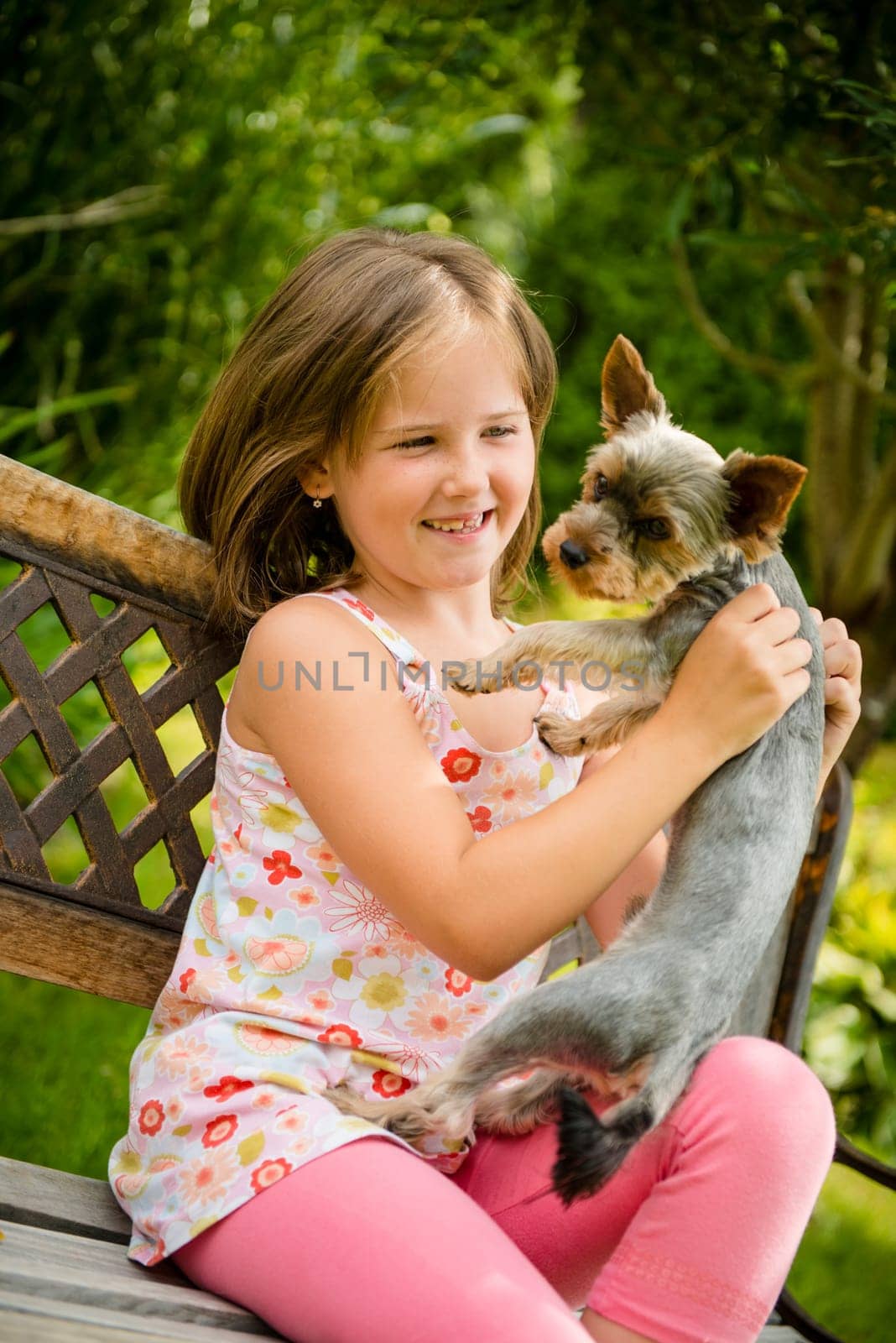 Happy smiling child playing with their pet - outdoor in backyard