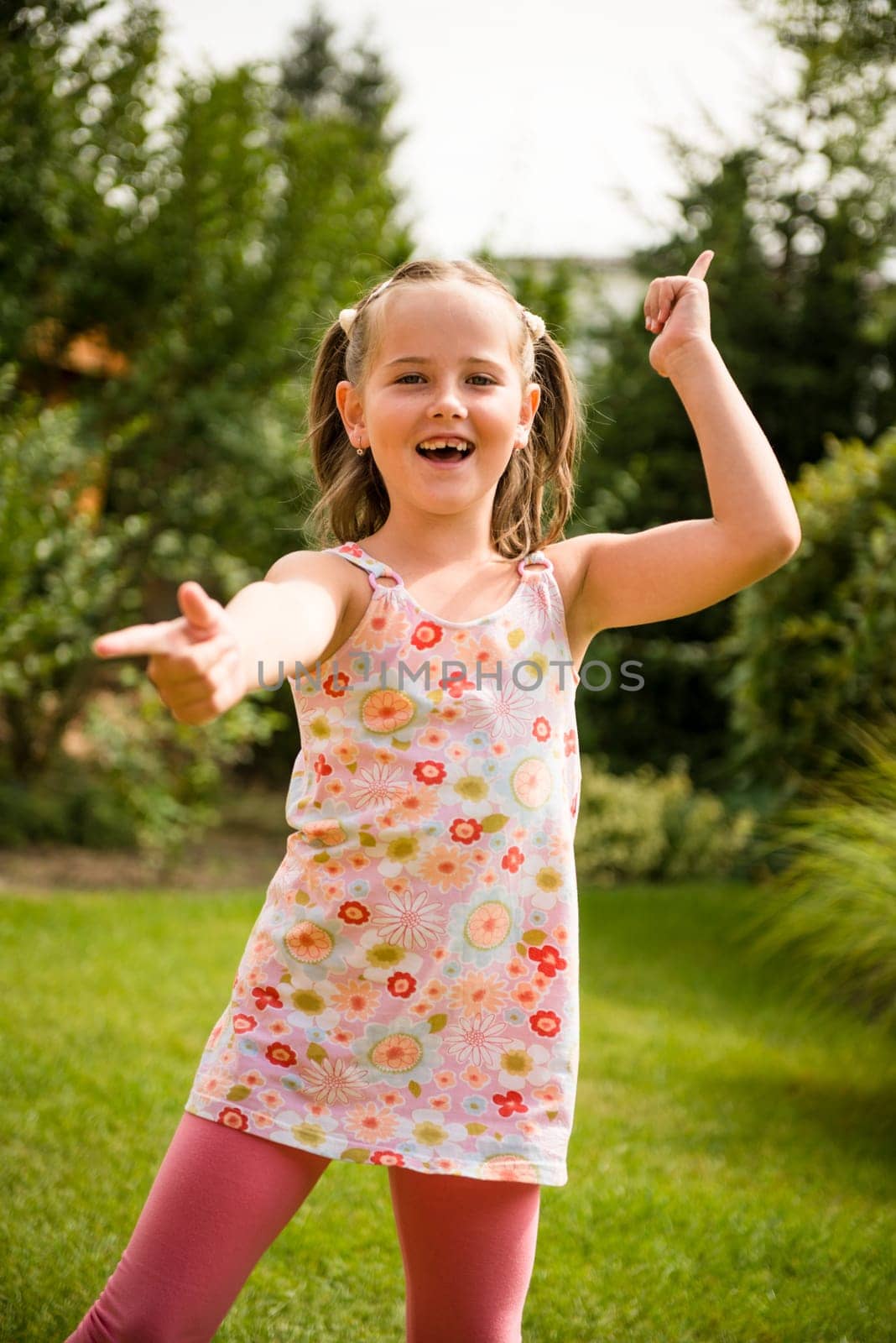 Active childhood - happy child dancing outdoor in backyard