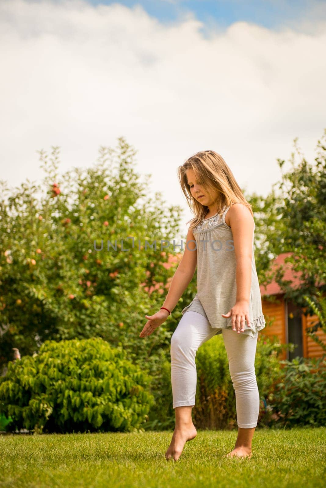 Active childhood - little child concentrating before performing handstand
