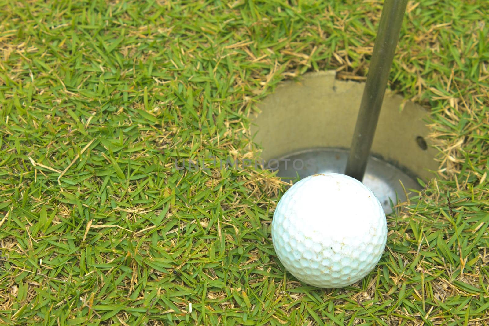 Golf ball on grass lip of the hole