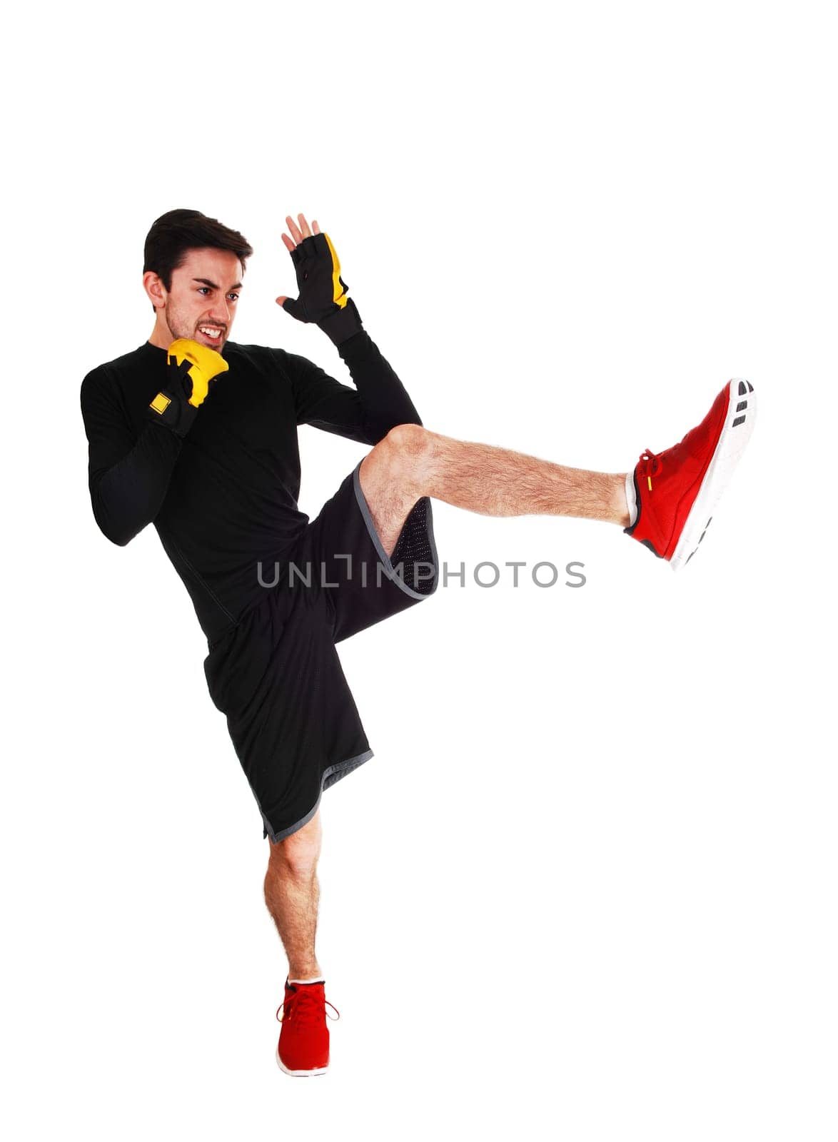 A young man in a exercising outfit doing kicking for white background..