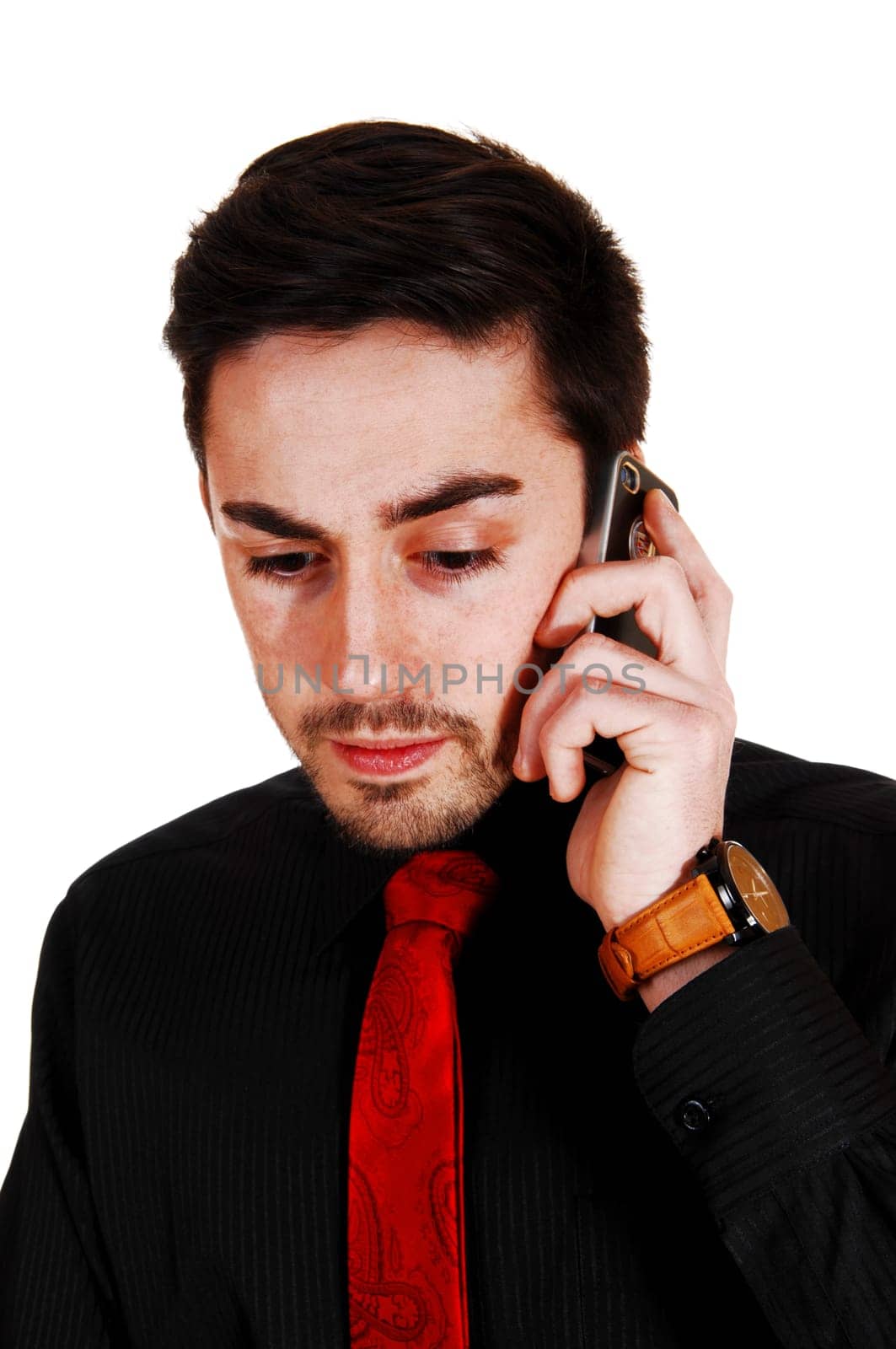 A young man talking on a cell phone in a black shirt and red tie with a beard.for white background..