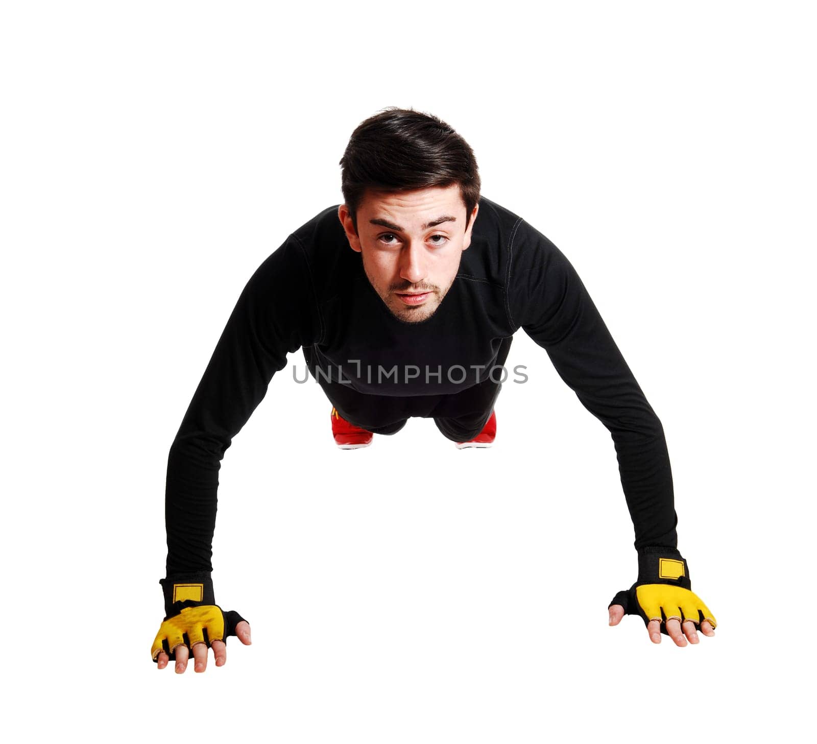 A young man in exercise clothing doing pushes on the floor for.white background..