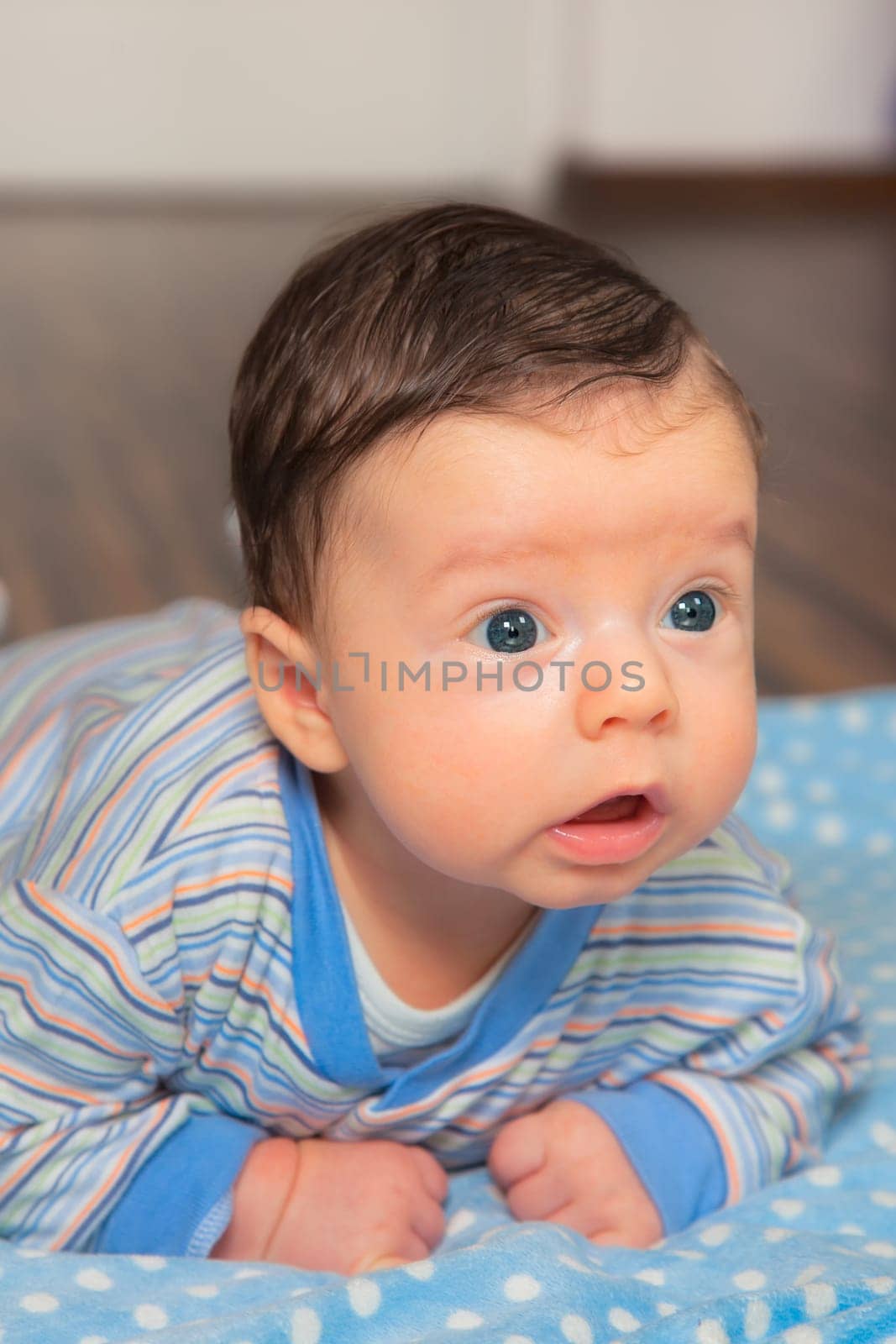 Portrait of 2 months baby boy doing tummy time at home.