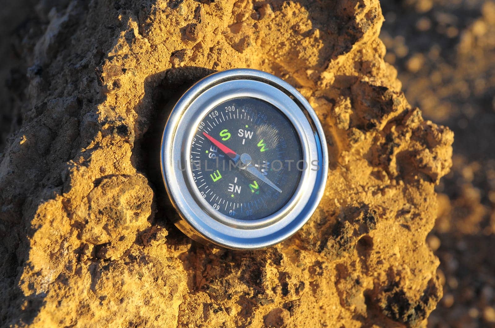 Orientation Concept Metal Compass on a Rock in the Desert