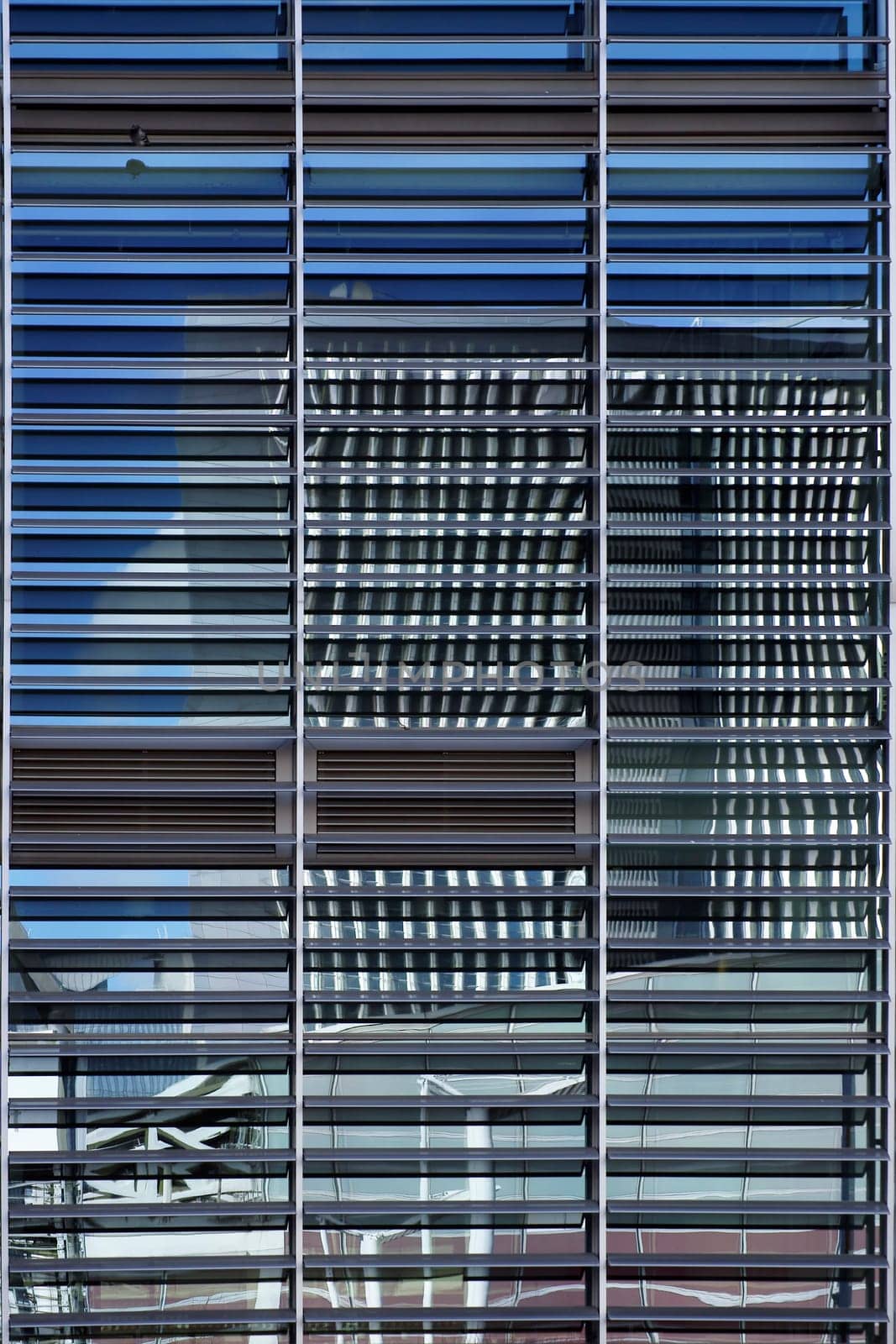 The abstract photograph of high-rise reflections in a façade with blinds