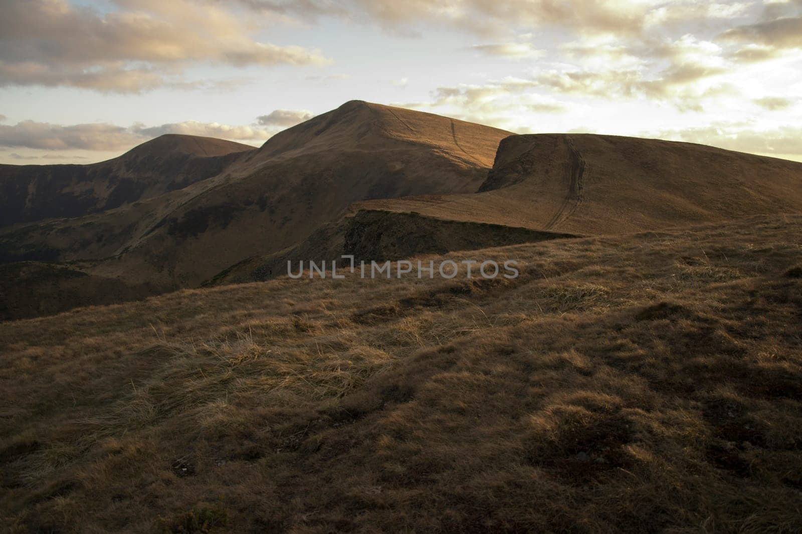Mountain peaks in the autumn evening sky with clouds