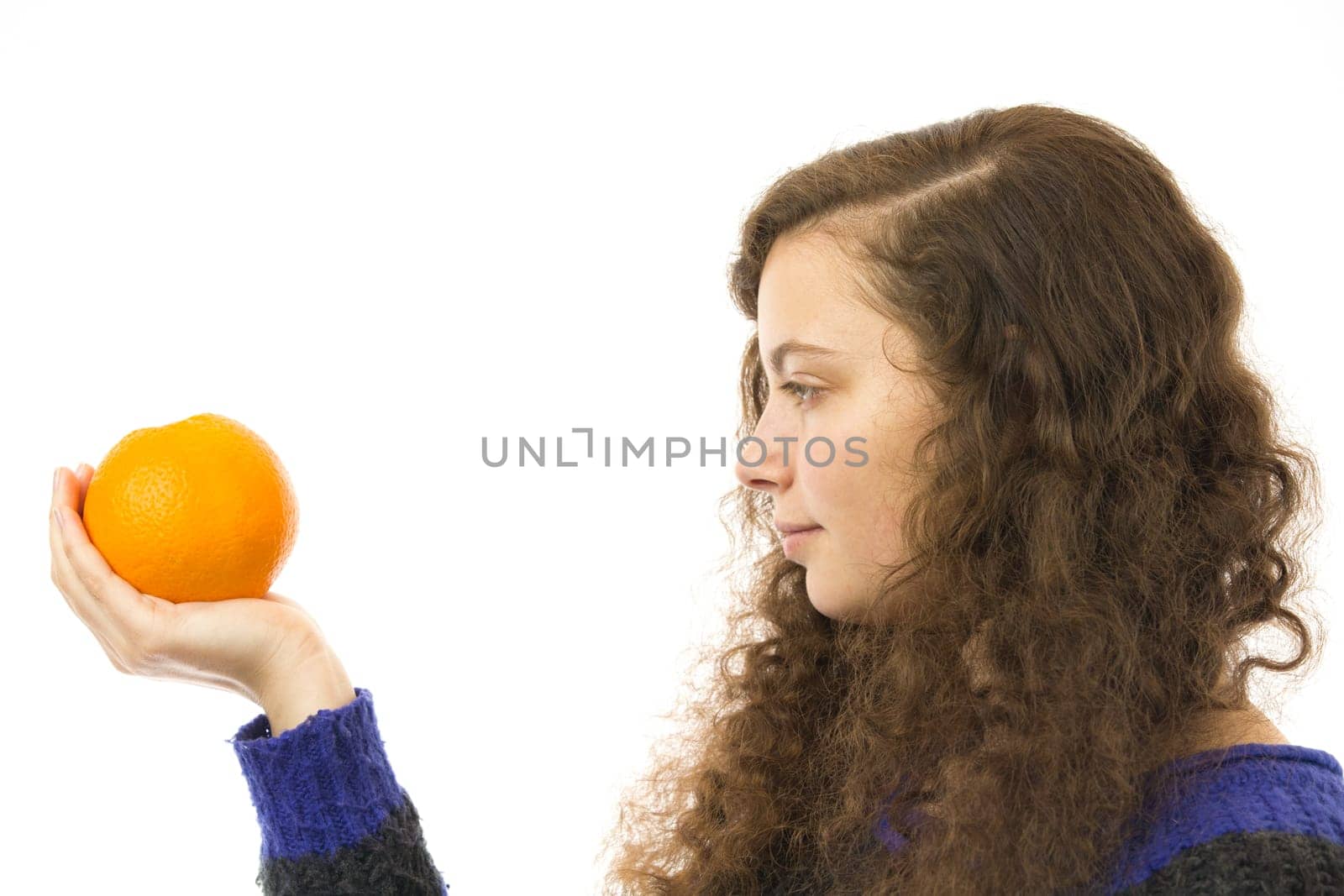 Eine junge hübsche Frau hält eine Orange in der Hand