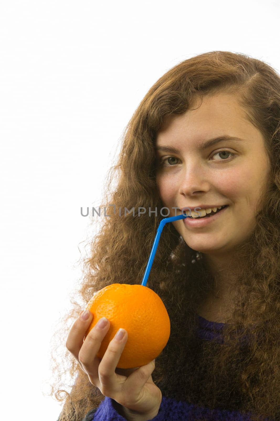 Eine junge hübsche Frau hält eine Orange mit Strohhalm in der Hand