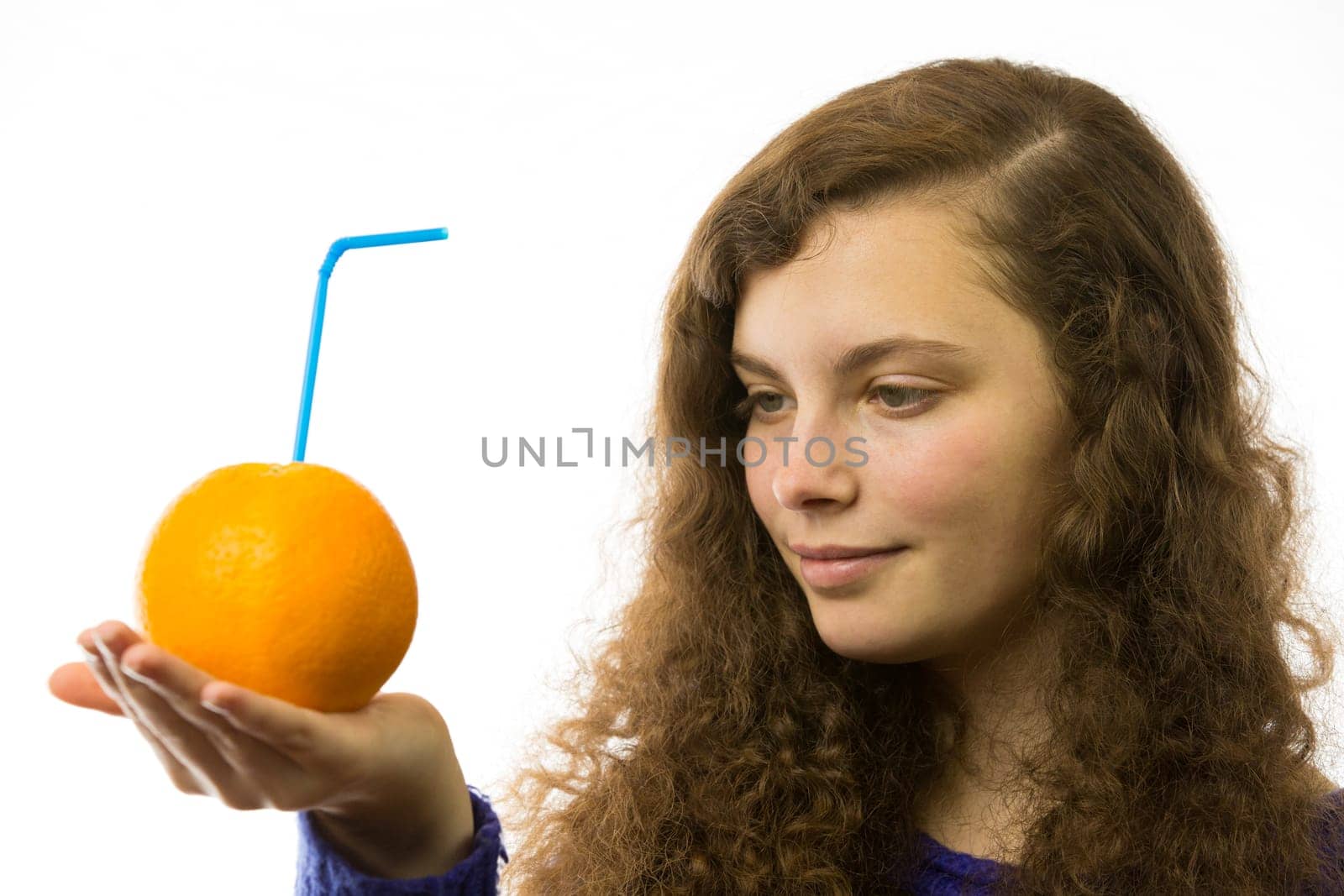Eine junge hübsche Frau hält eine Orange mit Strohhalm in der Hand