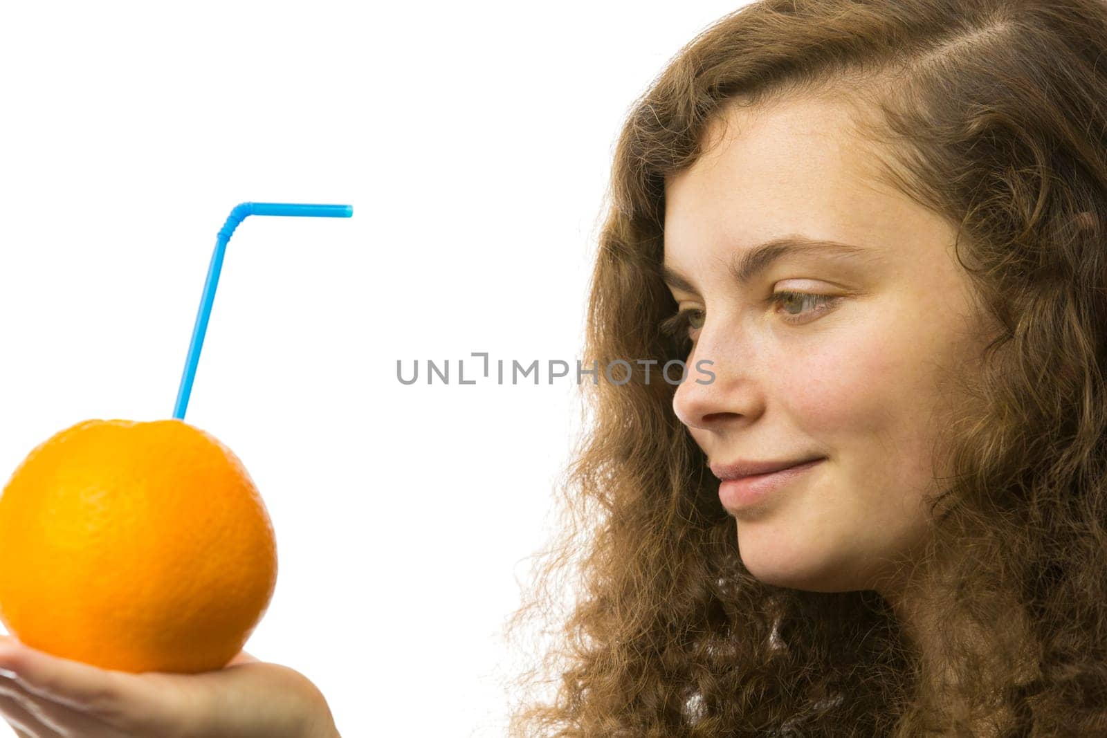 Eine junge hübsche Frau hält eine Orange mit Strohhalm in der Hand