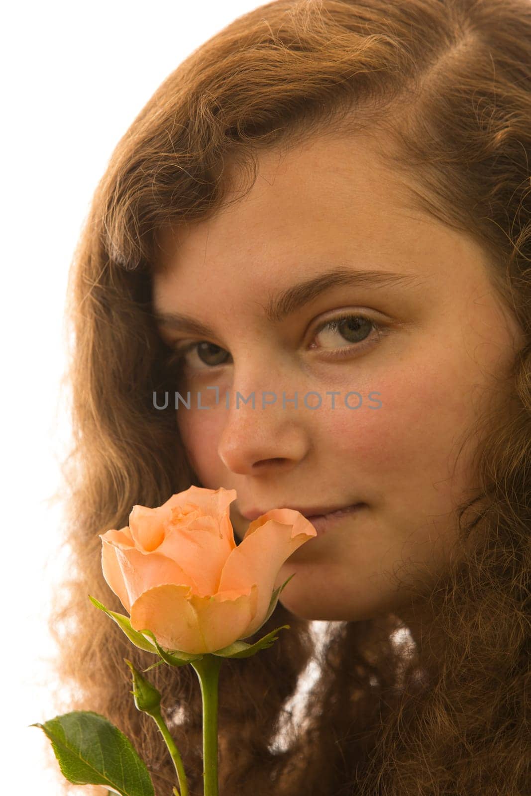 A young beautiful woman holds a rose in her hand
