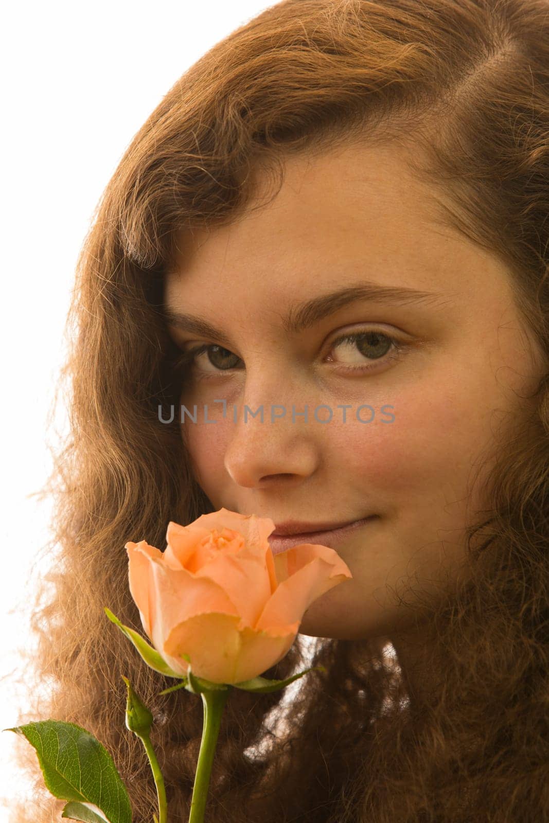 A young beautiful woman holds a rose in her hand