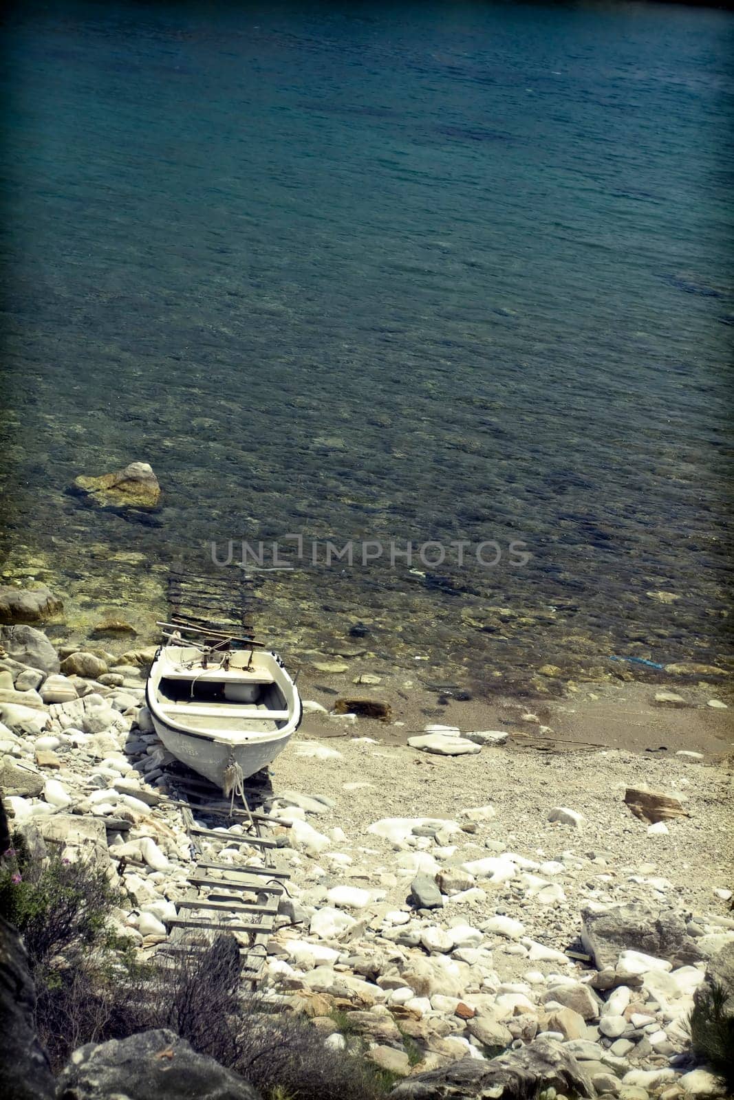 Vintage photo of lonely boat in a beautiful clear water lagoon