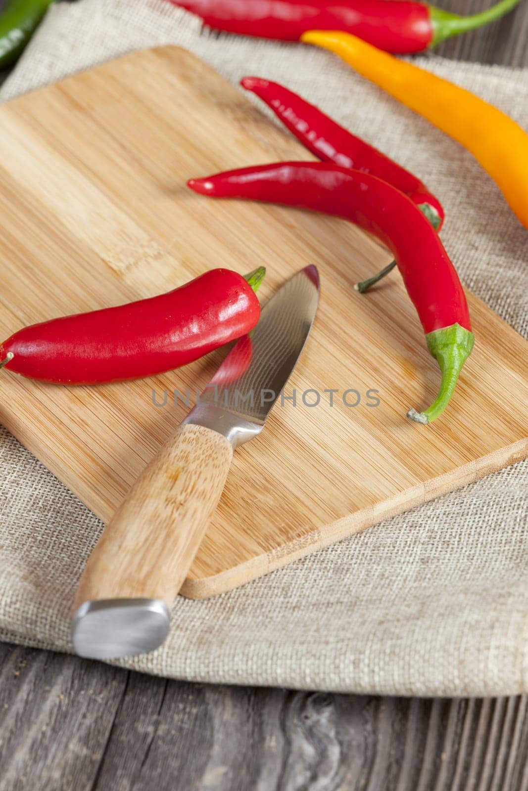 Chili peppers on cutting board with knife and text space