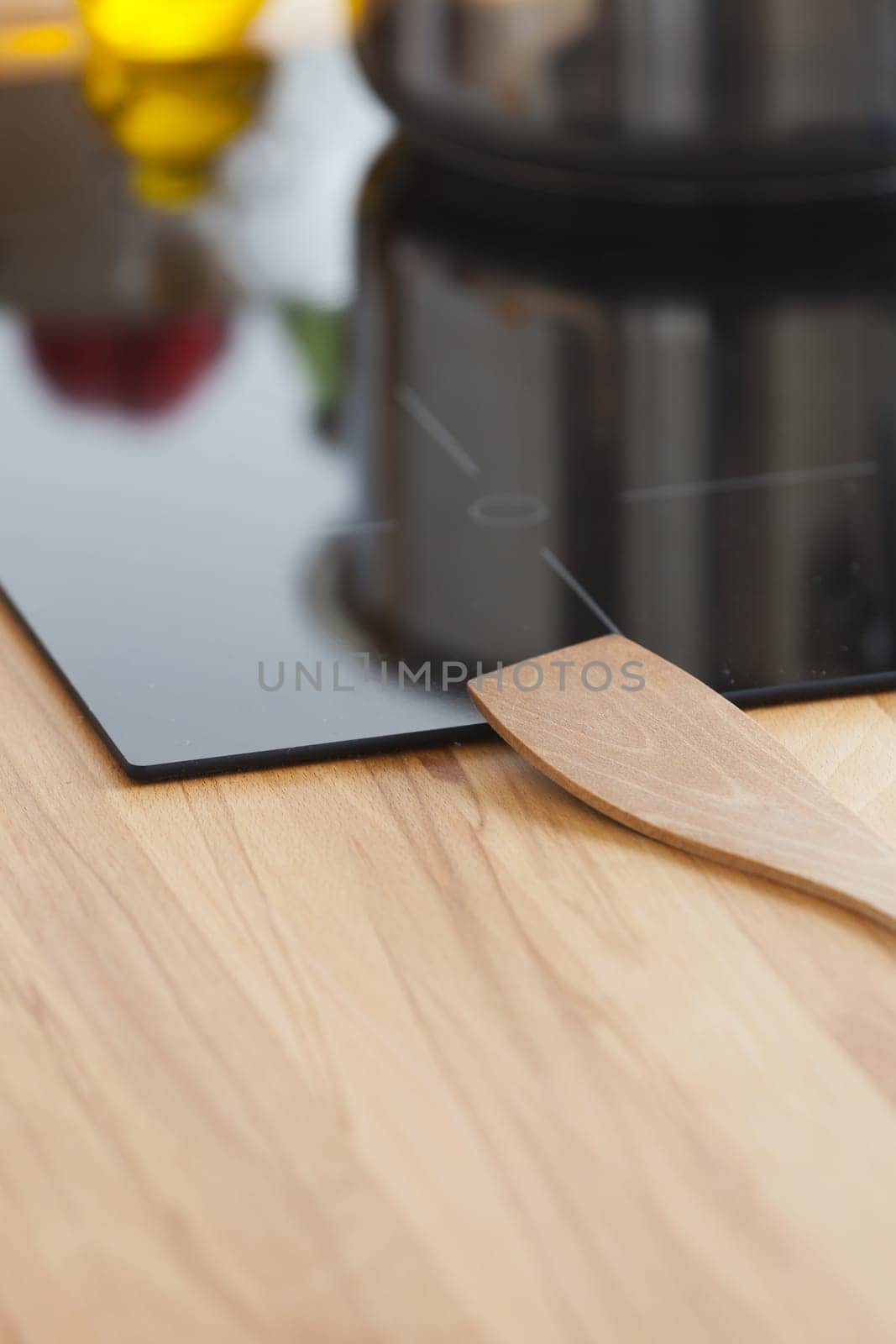 Wooden spoon lies on ceramic hob in kitchen