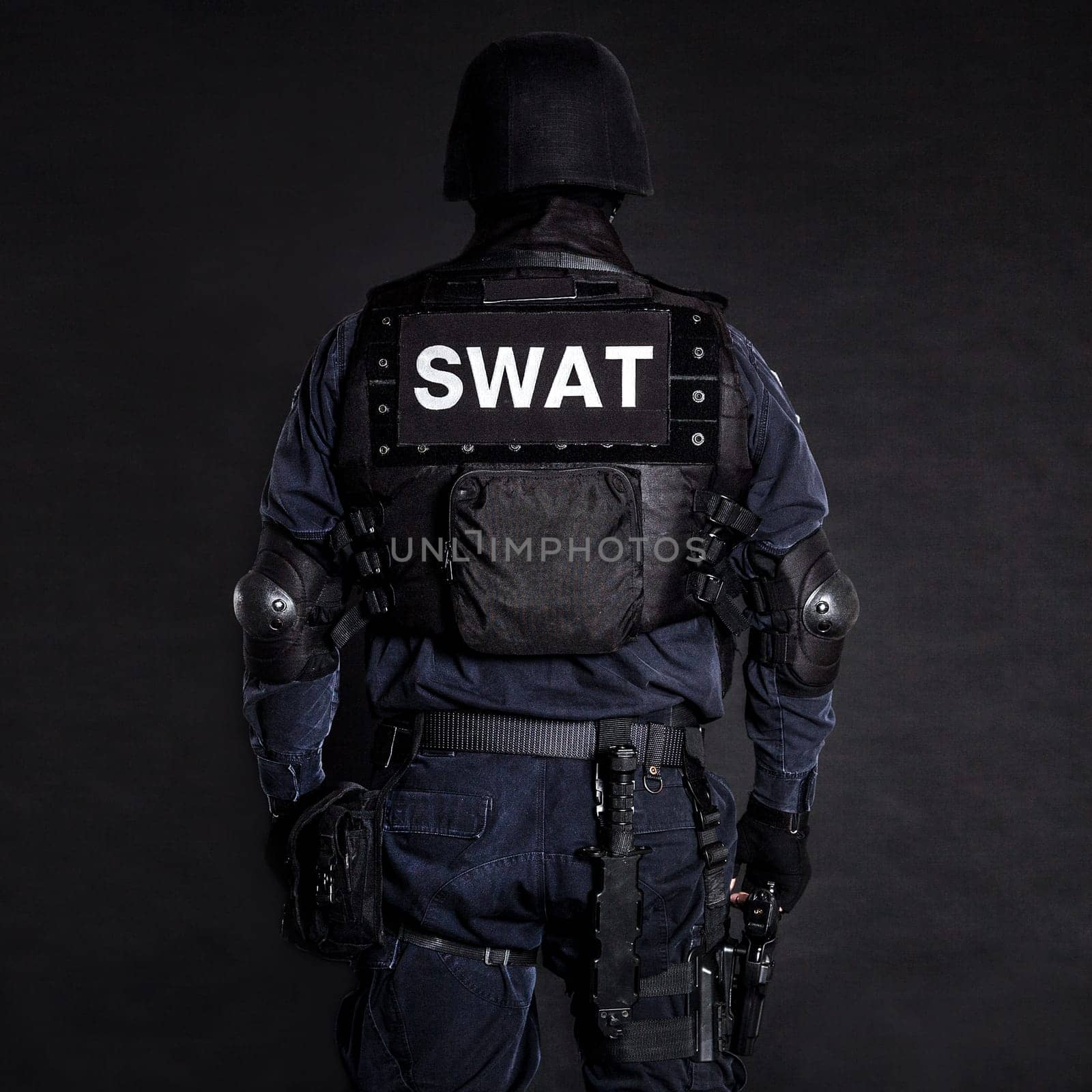 Special weapons and tactics (SWAT) team officer on black background shot from behind