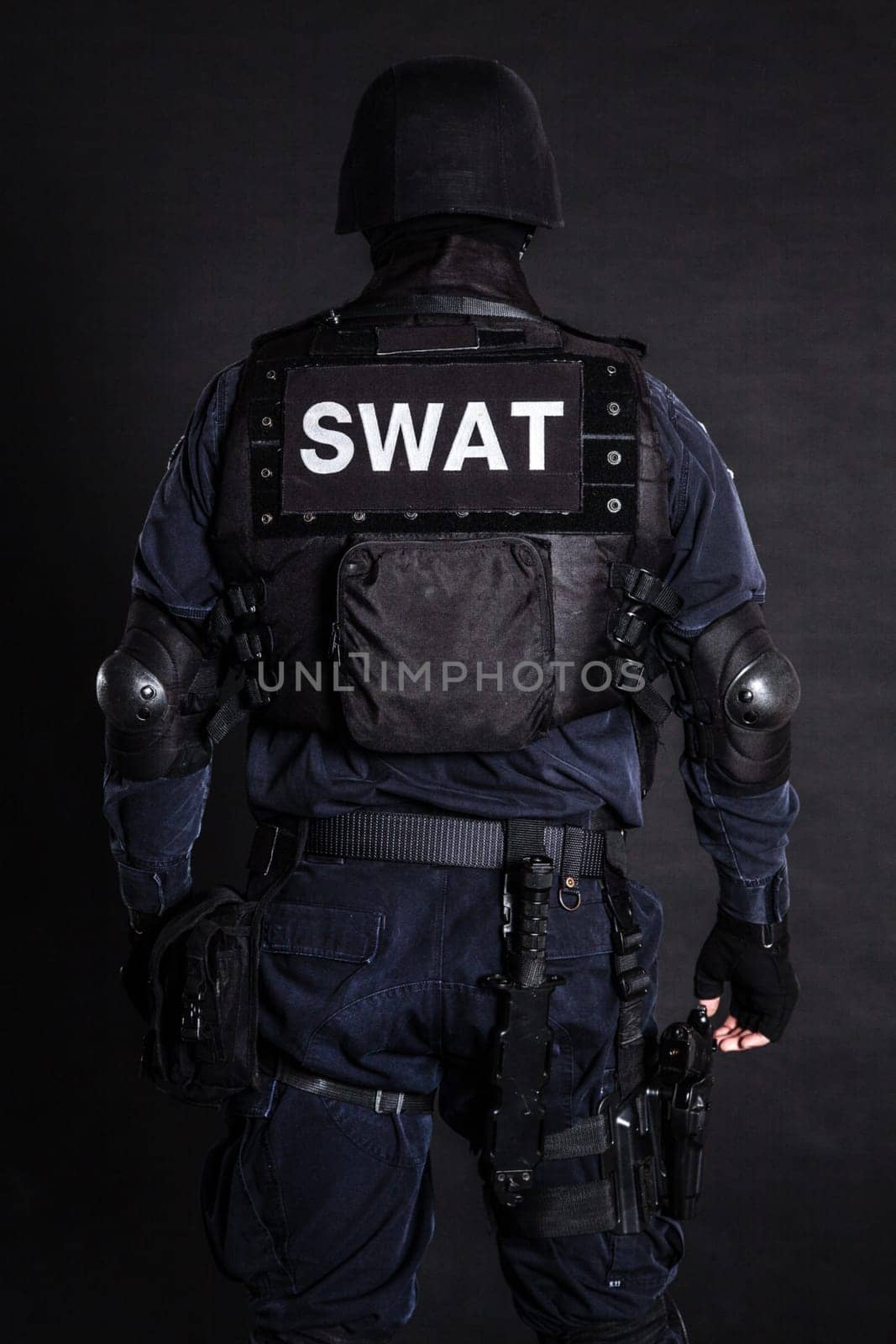 Special weapons and tactics (SWAT) team officer on black background shot from behind