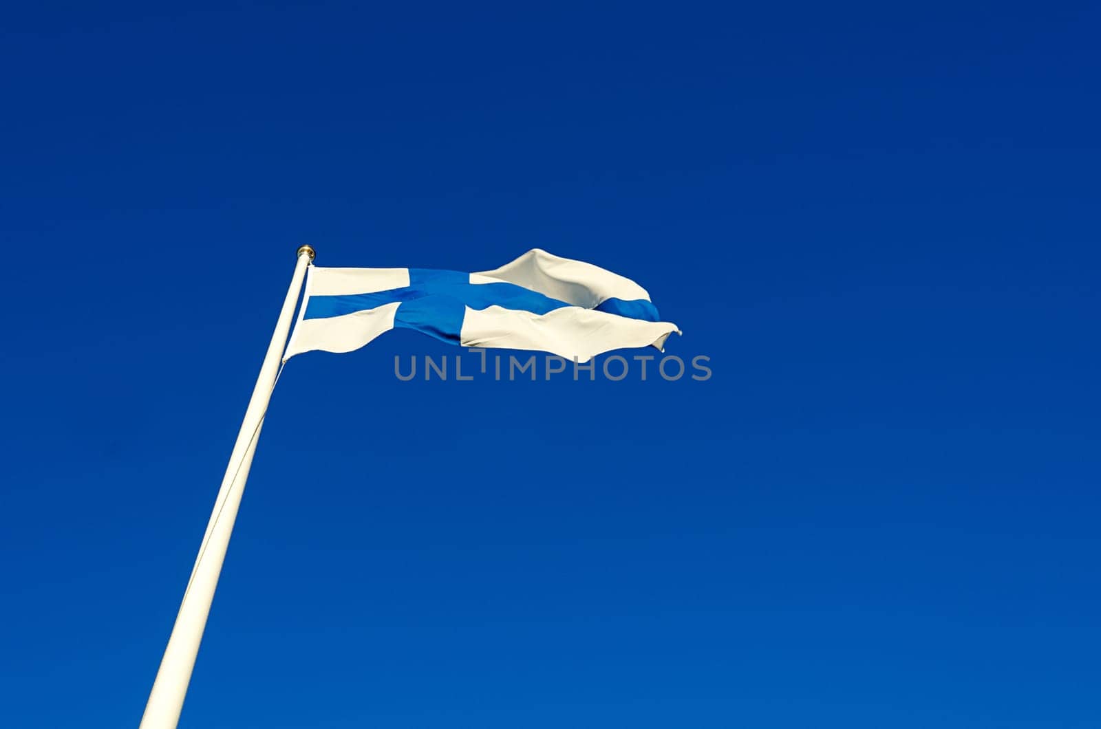 Finnish flag against a blue summer sky on a sunny day