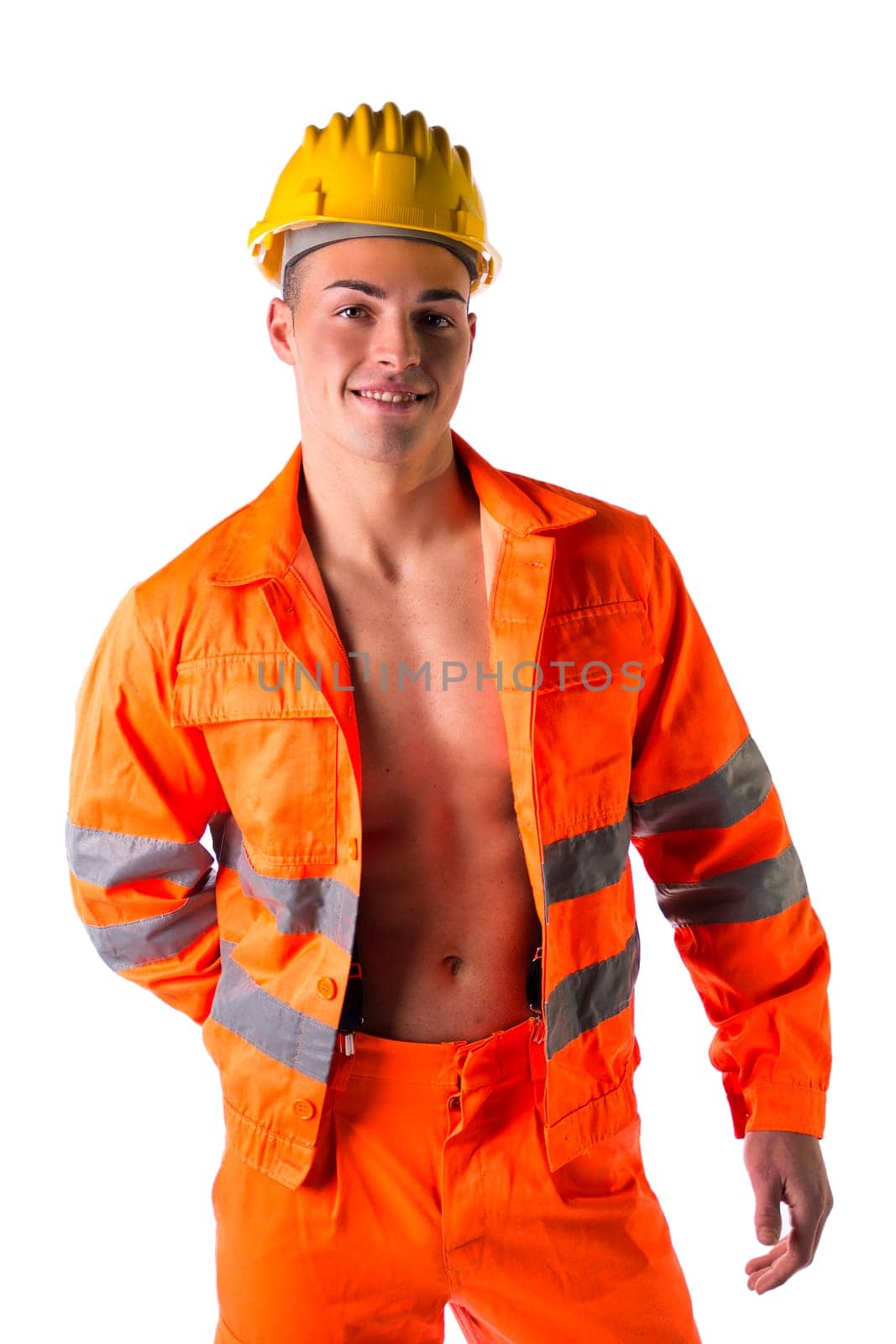 Handsome young construction worker with orange suit open on naked torso, smiling