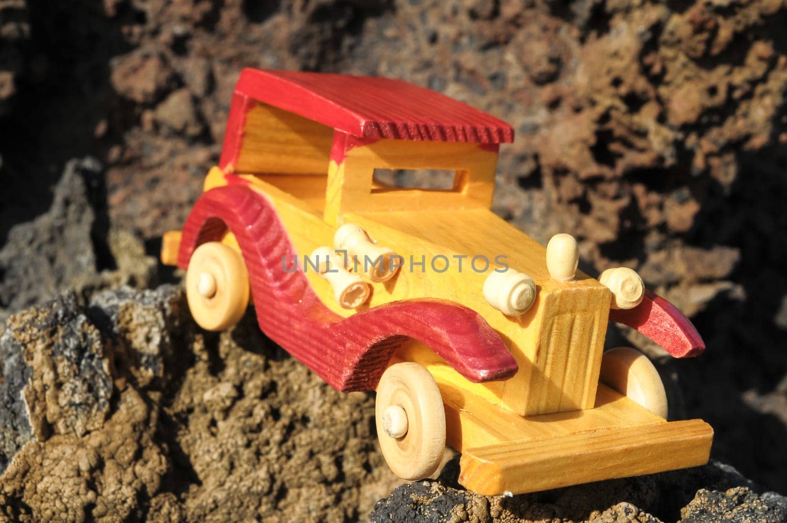 Transportation Concept Wooden Toy Car on the Rocks