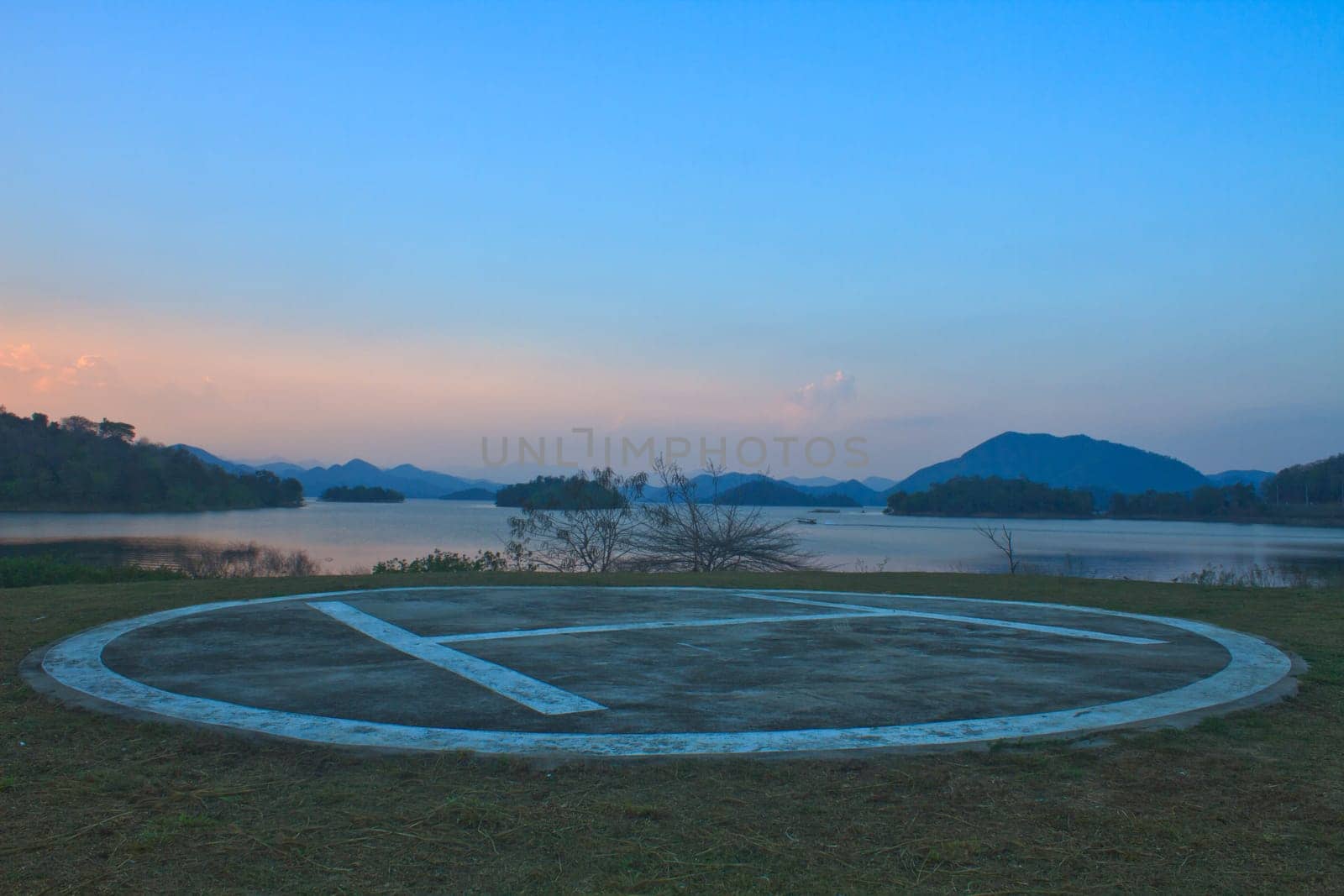 Helipad area for helicopter parking near lake on sunset